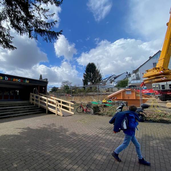 Blick auf den Eingang der Schule. Rechts davon ist die Baustelle zu sehen.