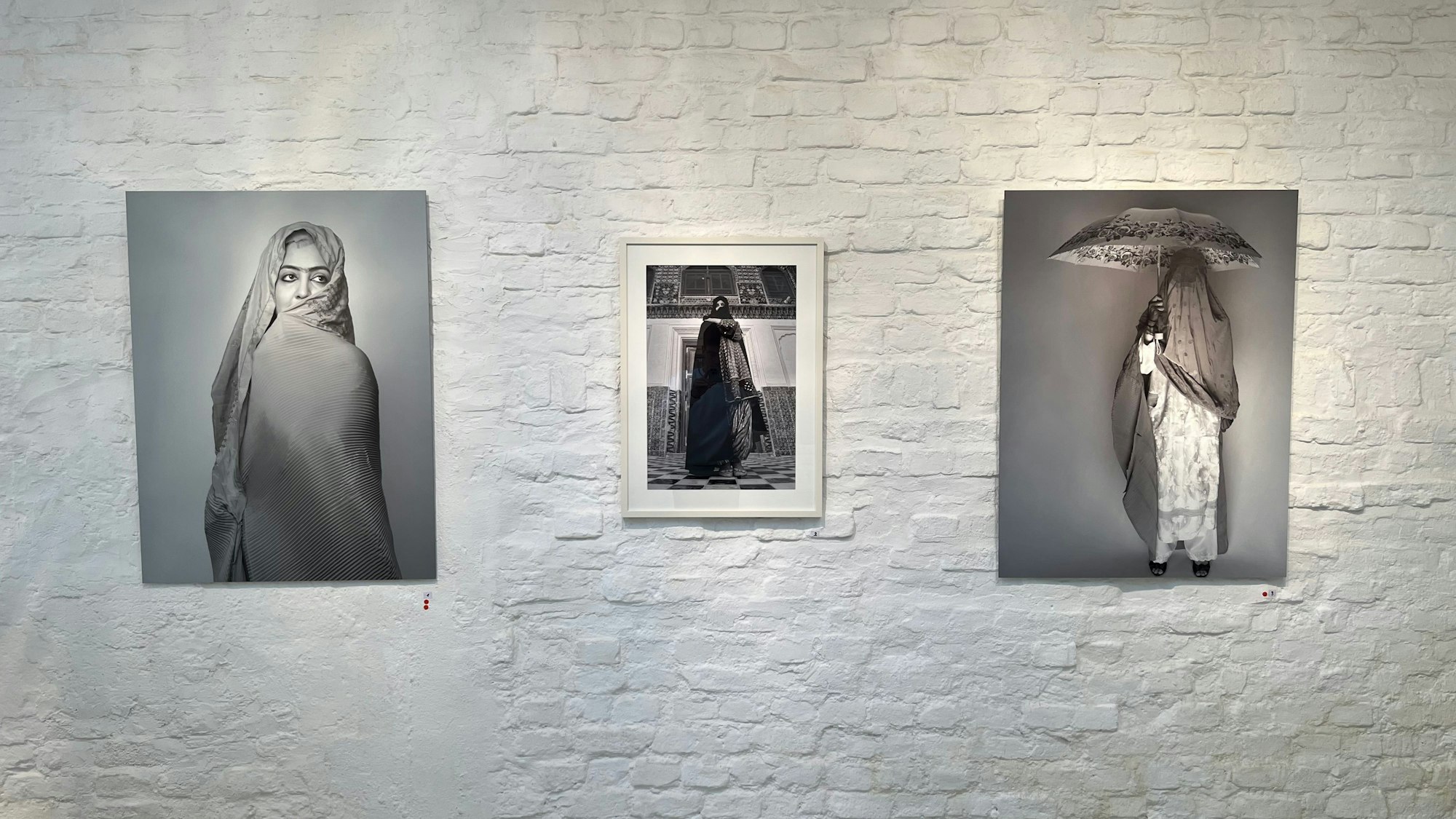 Mehrere Fotos an einer Wand nebeneinander