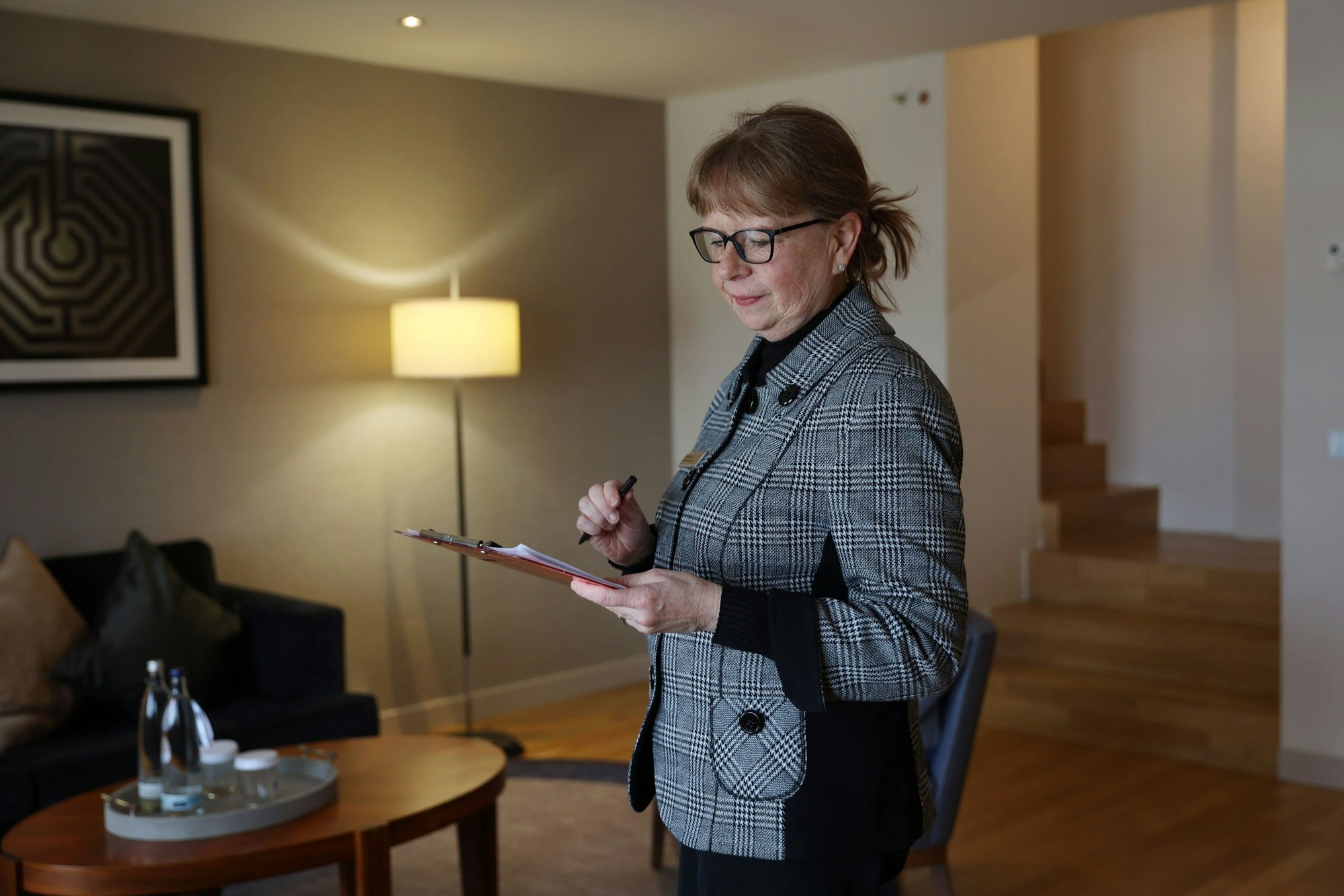 Andrea Pilz steht mit einer Checkliste im Hotelzimmer.