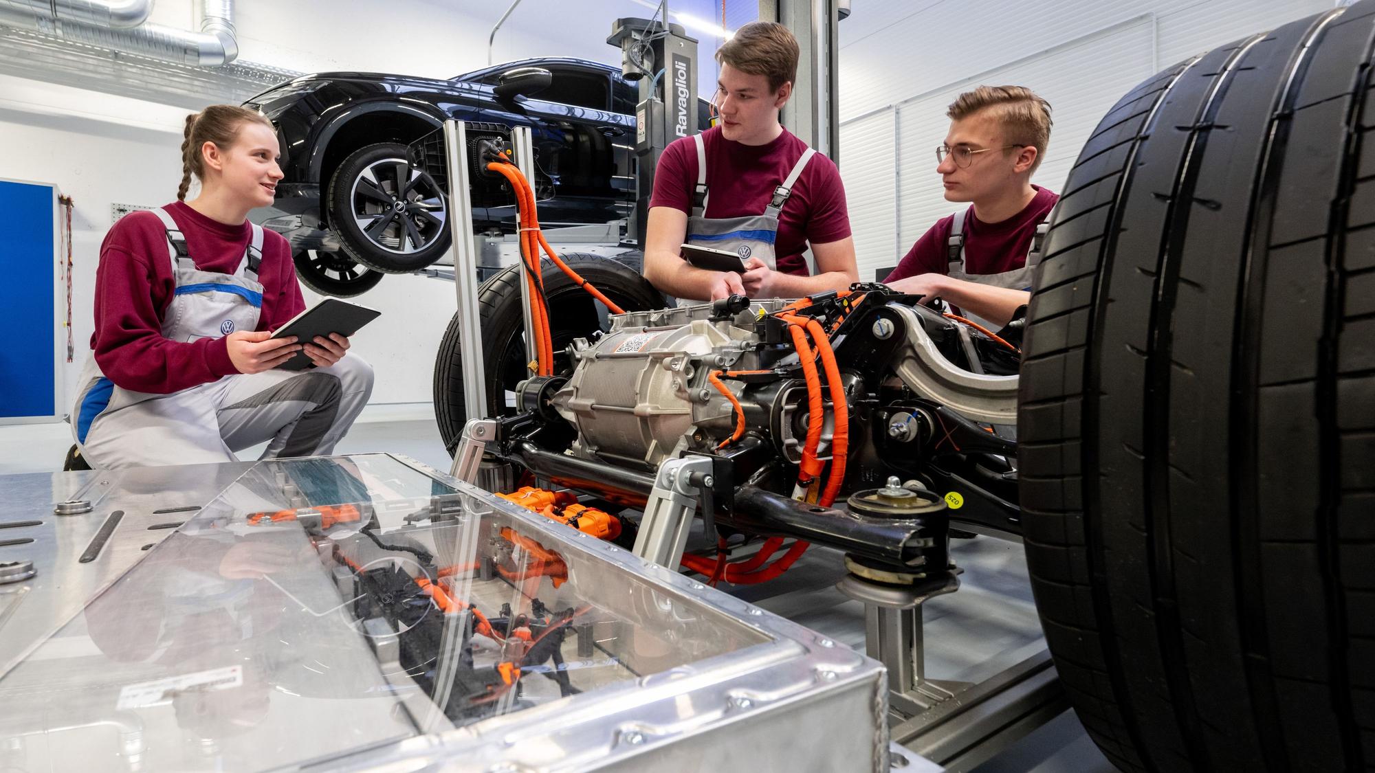 Die angehenden KfZ-Mechatroniker Simona Barthel, Maurice Kipping (M) und Louis Rose befassen sich mit dem Modell eines Modularen E-Antriebs-Baukasten von VW.