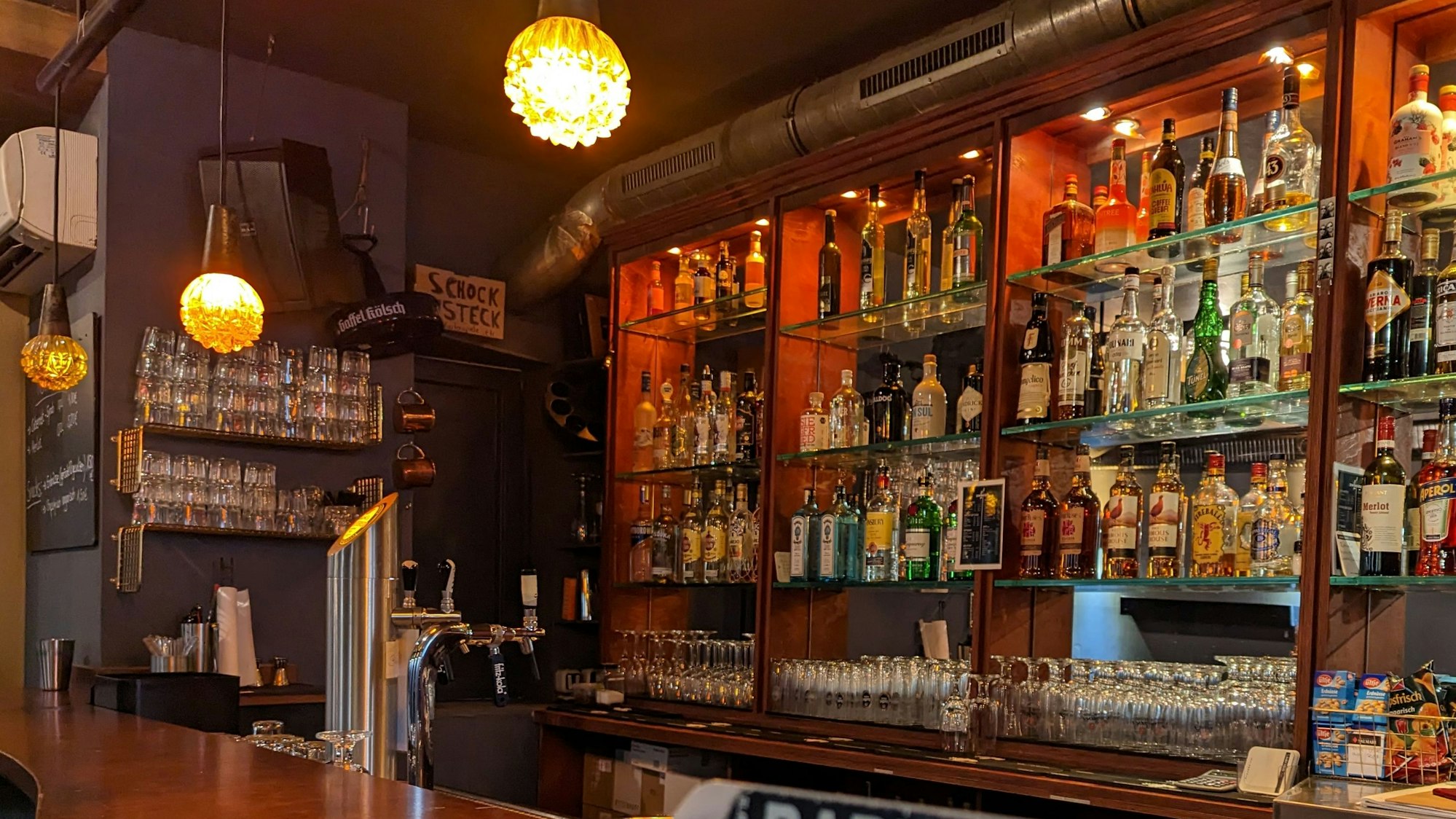 Blick auf die Bar des ZwoEinz. Im Vordergrund sieht man Sticker auf einem Thekenaufsatz.