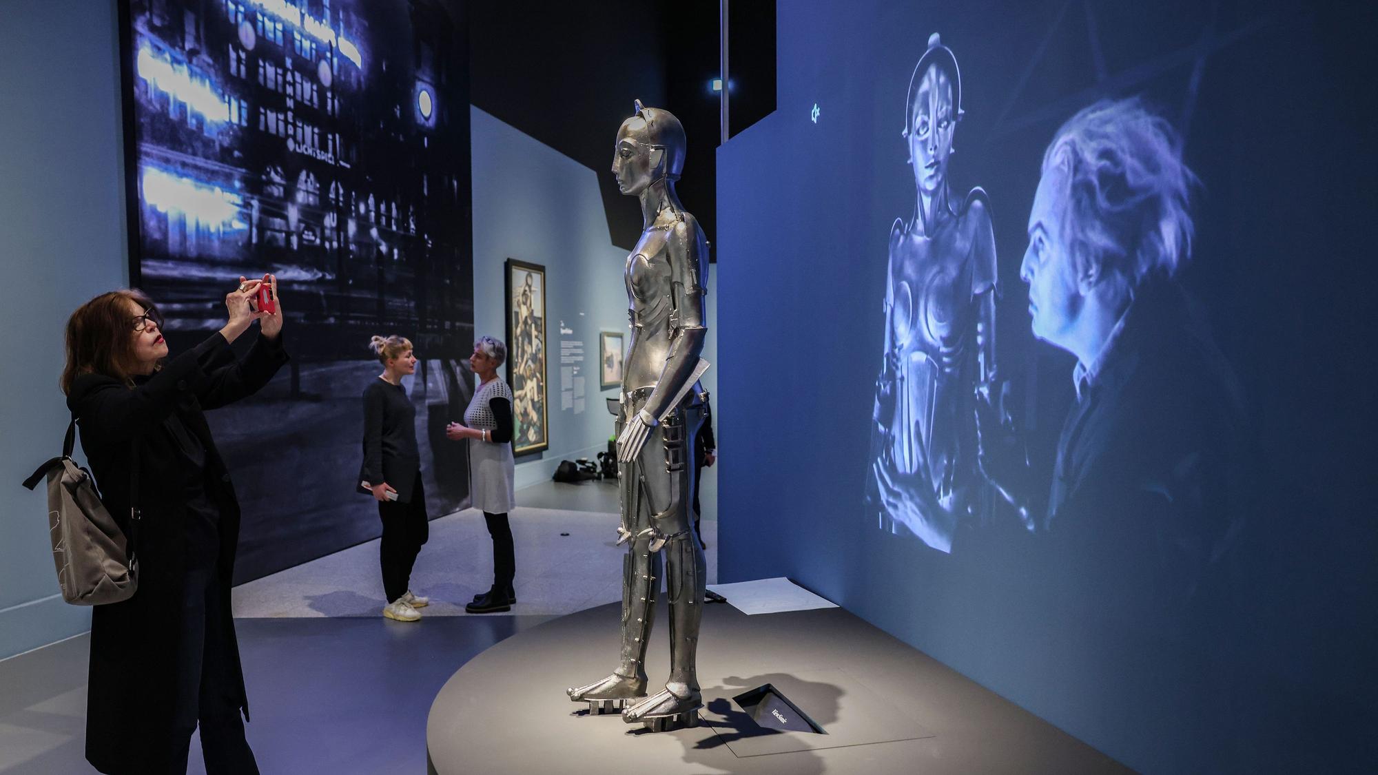 Eine Frau fotografiert den Nachbau des Maschinenmenschen aus dem Film "Metropolis".