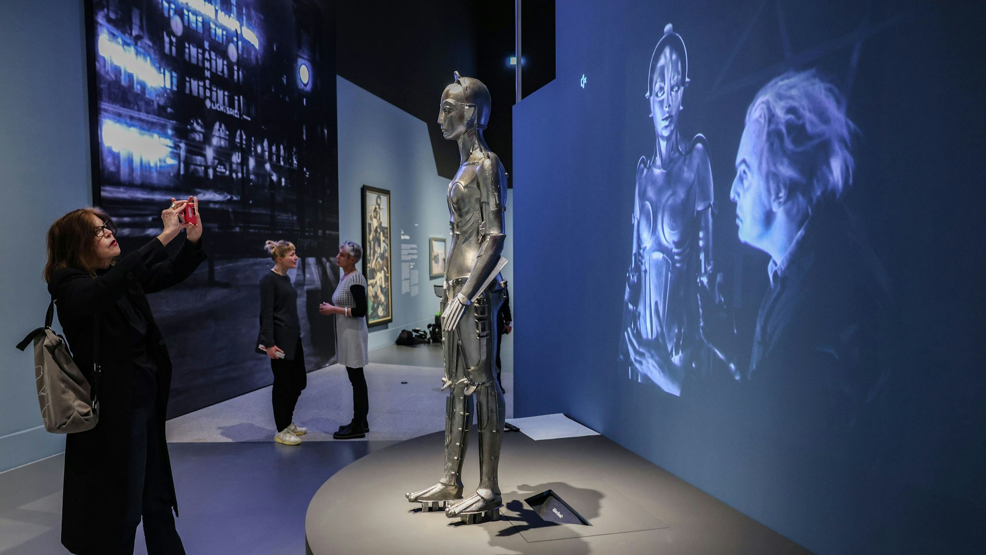 Eine Frau fotografiert den Nachbau des Maschinenmenschen aus dem Film "Metropolis".