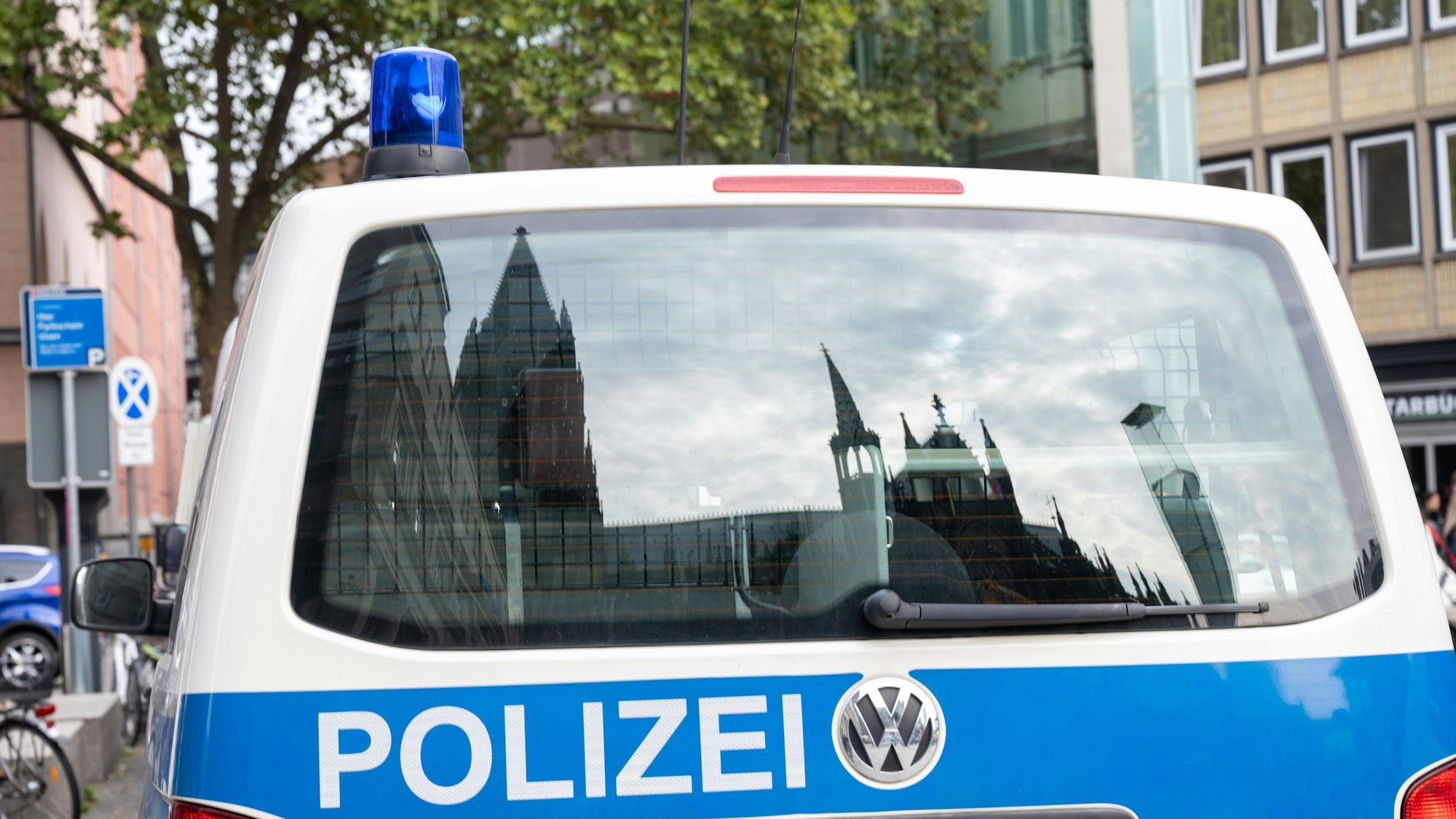 Der Dom spiegelt sich in einem Fenster eines Polizeifahrzeuges.