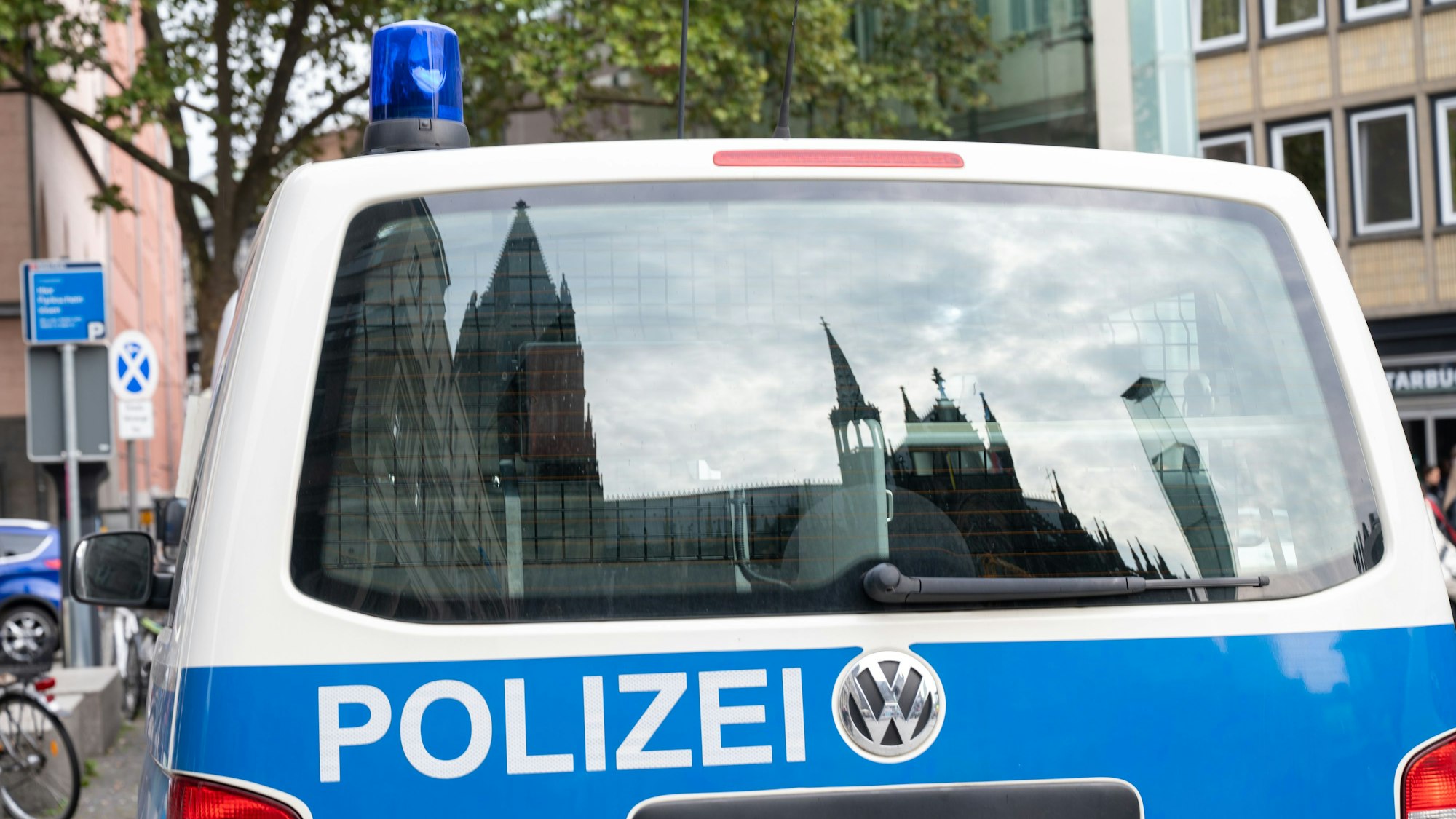 Der Dom spiegelt sich in einem Fenster eines Polizeifahrzeuges.