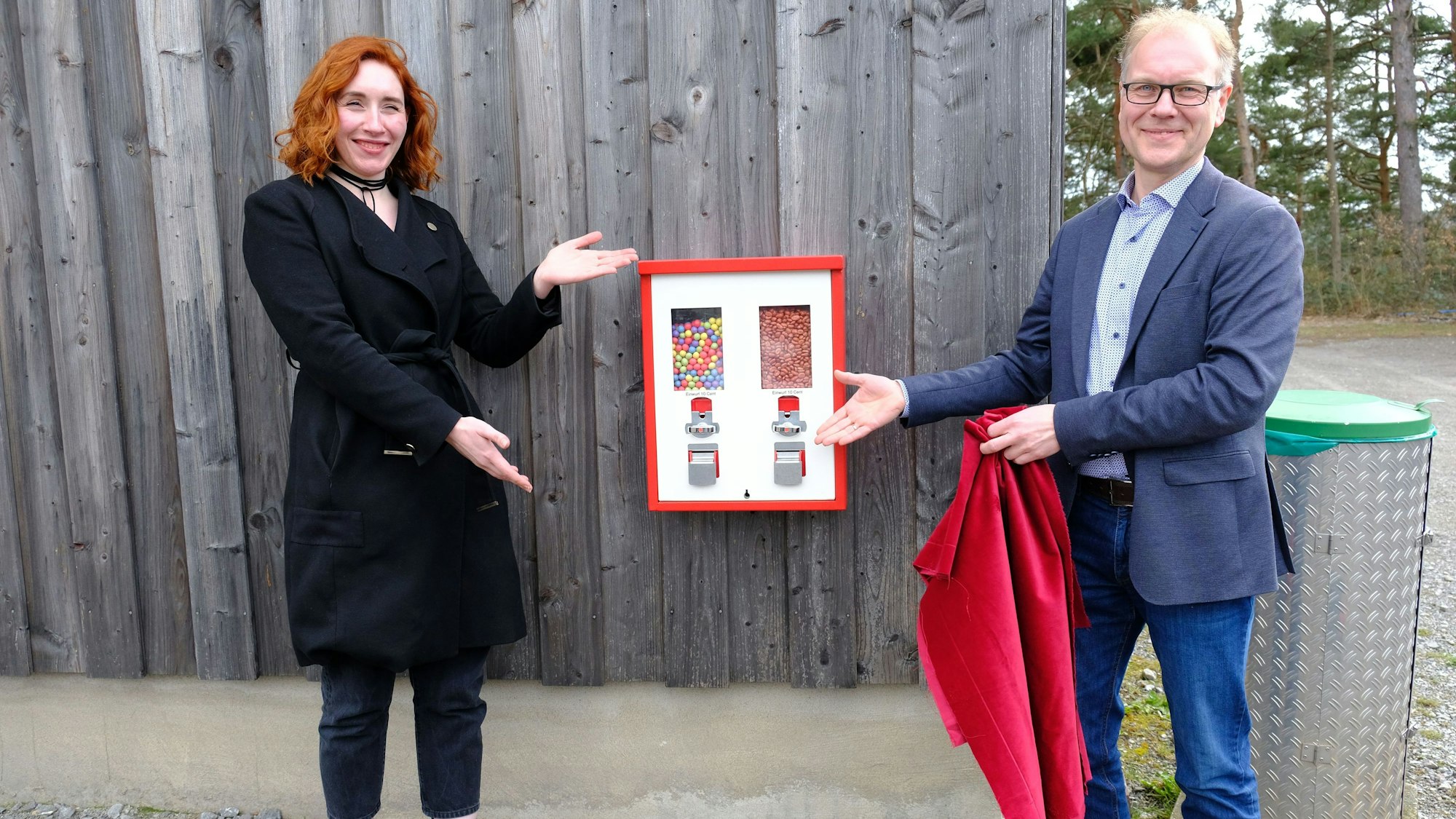 Museumsleiter Carsten Vorwig und Ann Heinen zeigen auf einen Kaugummiautomaten.