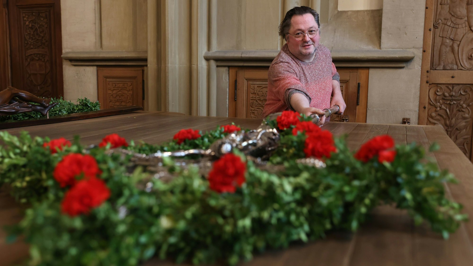 Mann mit einem blumengeschmückten Silberkreuz
