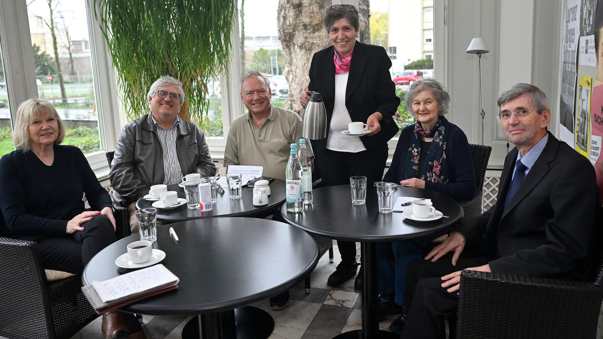 Die Bürgermeisterin von Runnymede sitzt in einer Gesprächsrunde und bekommt ein Heißgetränk serviert.