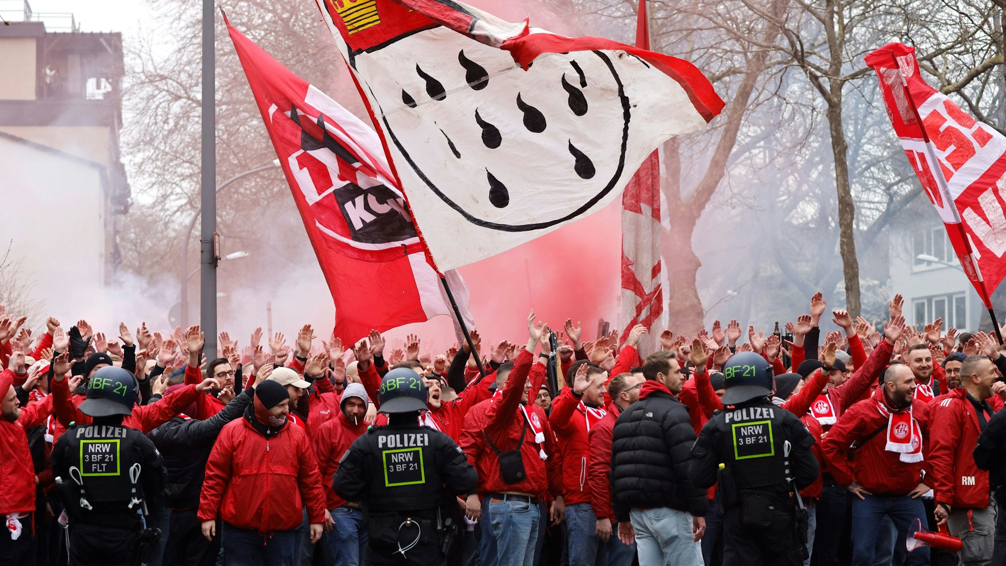 Mehrere Hundert Fans des 1. FC Köln ziehen vor dem Revierderby begleitet von Einsatzkräften der Polizei in einem Fanmarsch zum Stadion.