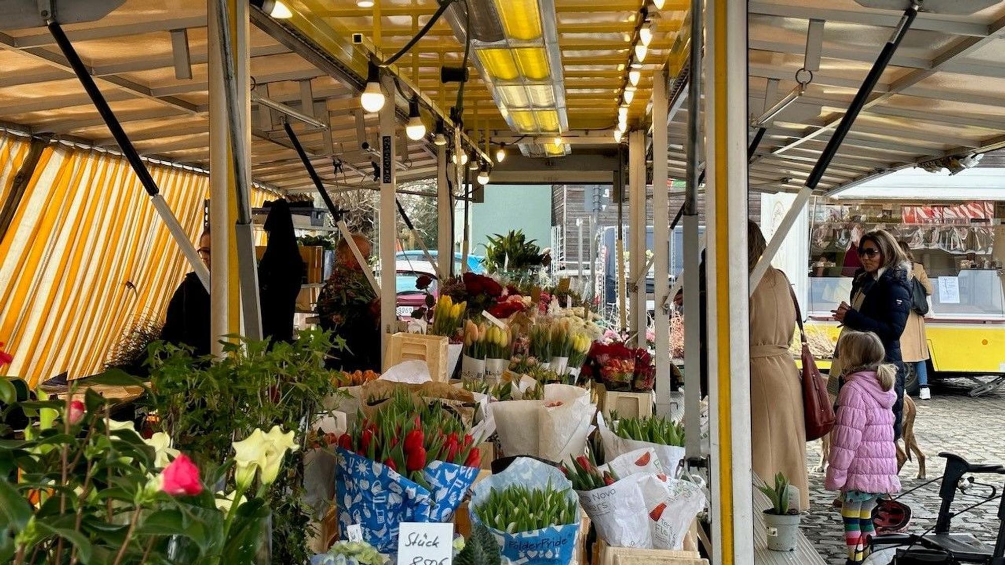 Ein Blumenstand auf einem Wochenmarkt.