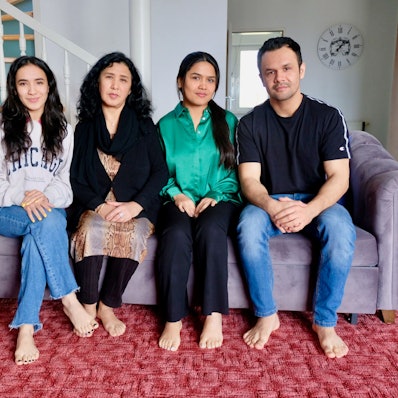 Familie Ashrafi sitzt auf dem Sofa.