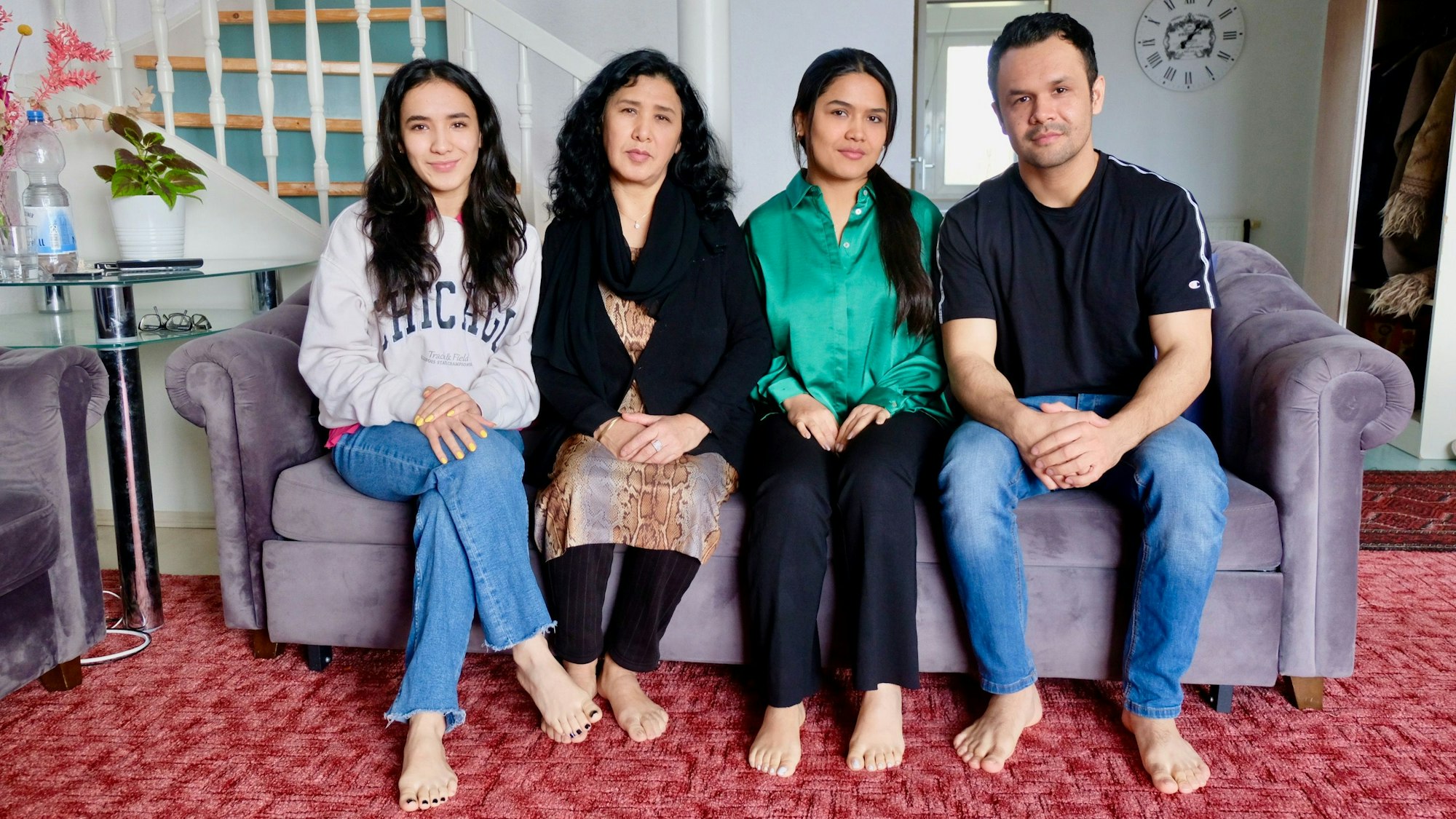 Familie Ashrafi sitzt auf dem Sofa.