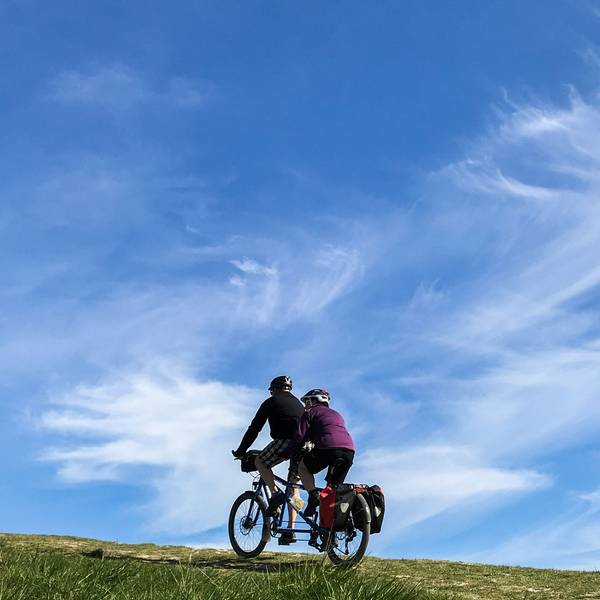 Ein Paar fährt mit einem Tandem einen Hügel hinauf.