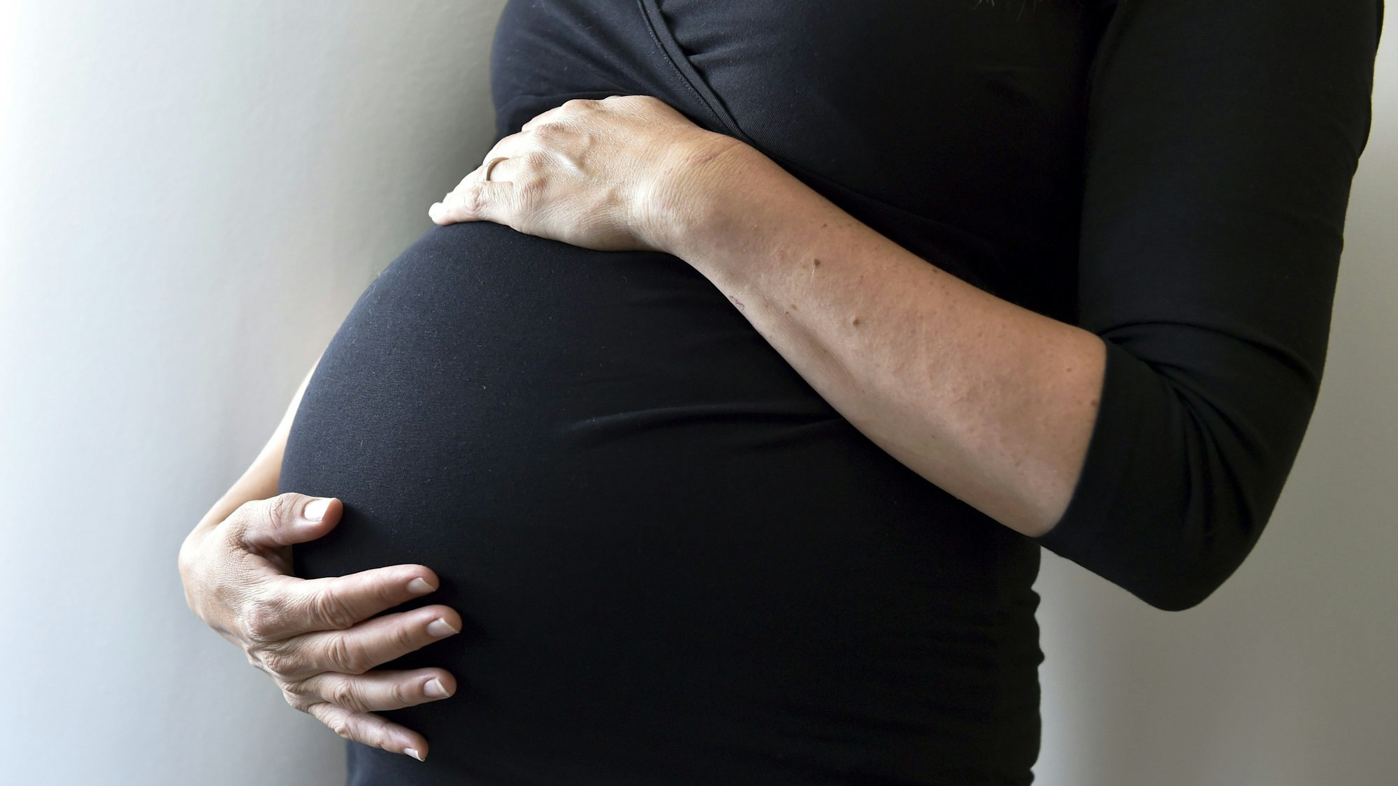 Eine schwangere Frau hält sich den Bauch. (Symbolbild)