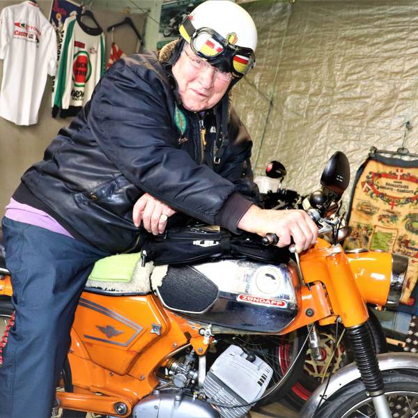 Der ehemalige Rennfahrer sitzt in seiner Garage auf seinem Motorrad.