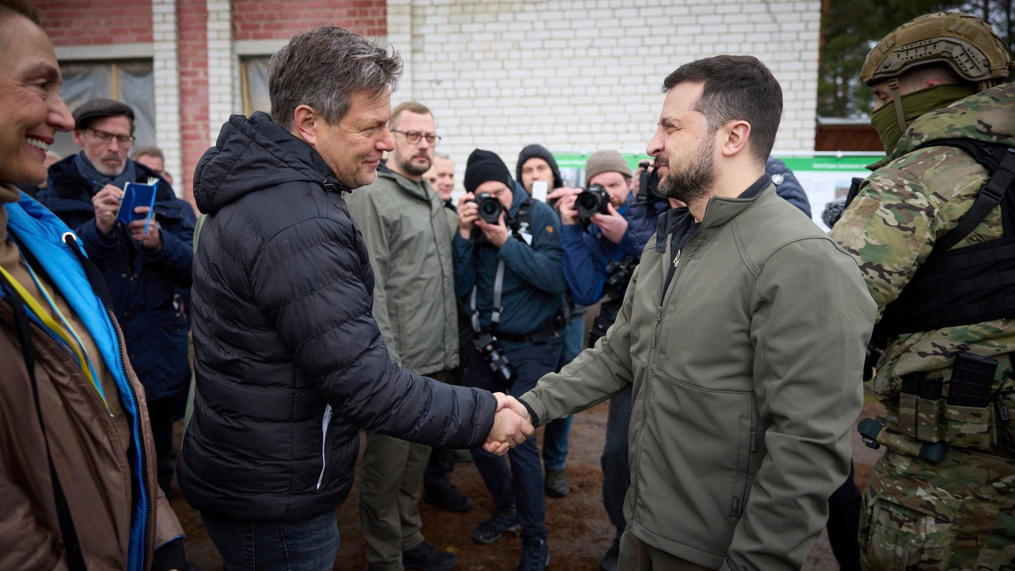 Wolodymyr Selenskyj (rechts), Präsident der Ukraine, und Robert Habeck (Bündnis 90/Die Grünen), Bundesminister für Wirtschaft und Klimaschutz, geben sich die Hand bei einem Besuch in Jahidne.