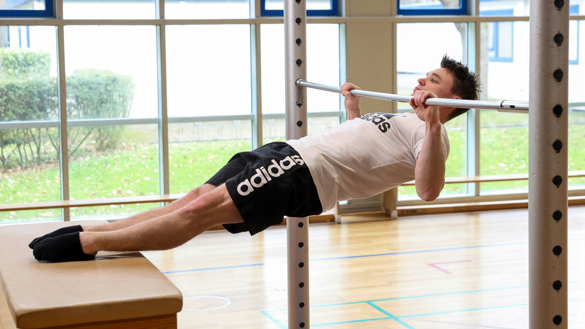 Jonas Rohleder zeigt eine Vorübung für den Klimmzug