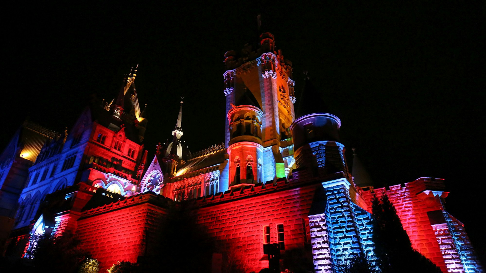Schloss Drachenburg in bunten Farben illuminiert.