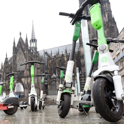Mehrere Elektroroller auf dem Bahnhofsvorplatz.