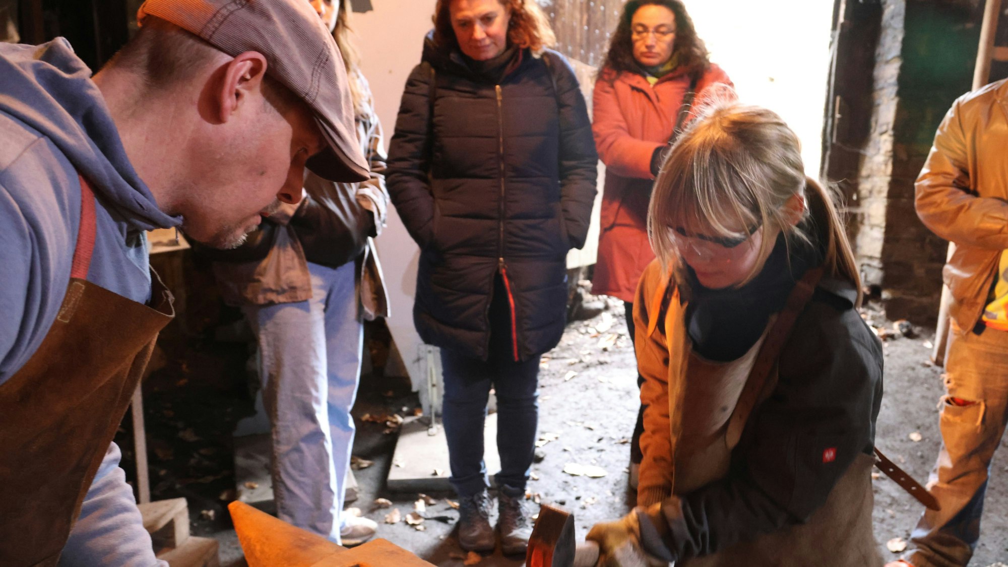 Ein Mädchen versucht sich mit einem Schmiedehammer.