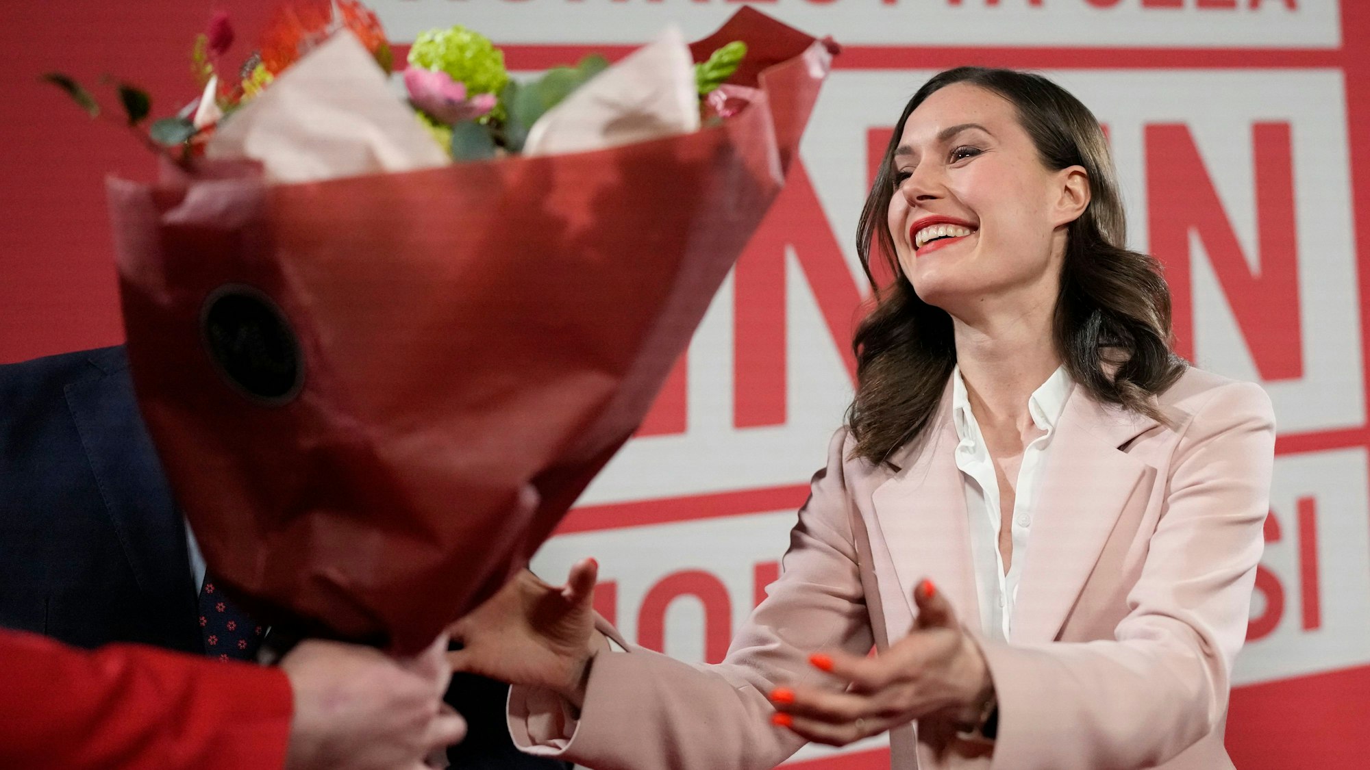 Die finnische Premierministerin Sanna Marin nimmt am Sonntagabend in Helsinki einen Blumenstrauß entgegen. Ihre sozialdemokratische Partei rutschte auf Rang drei bei der Parlamentswahl.