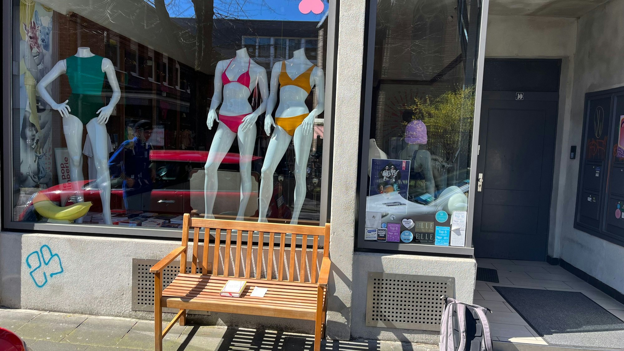 Eine braune Sitzbank vor einem Schaufenster in Ehrenfeld.