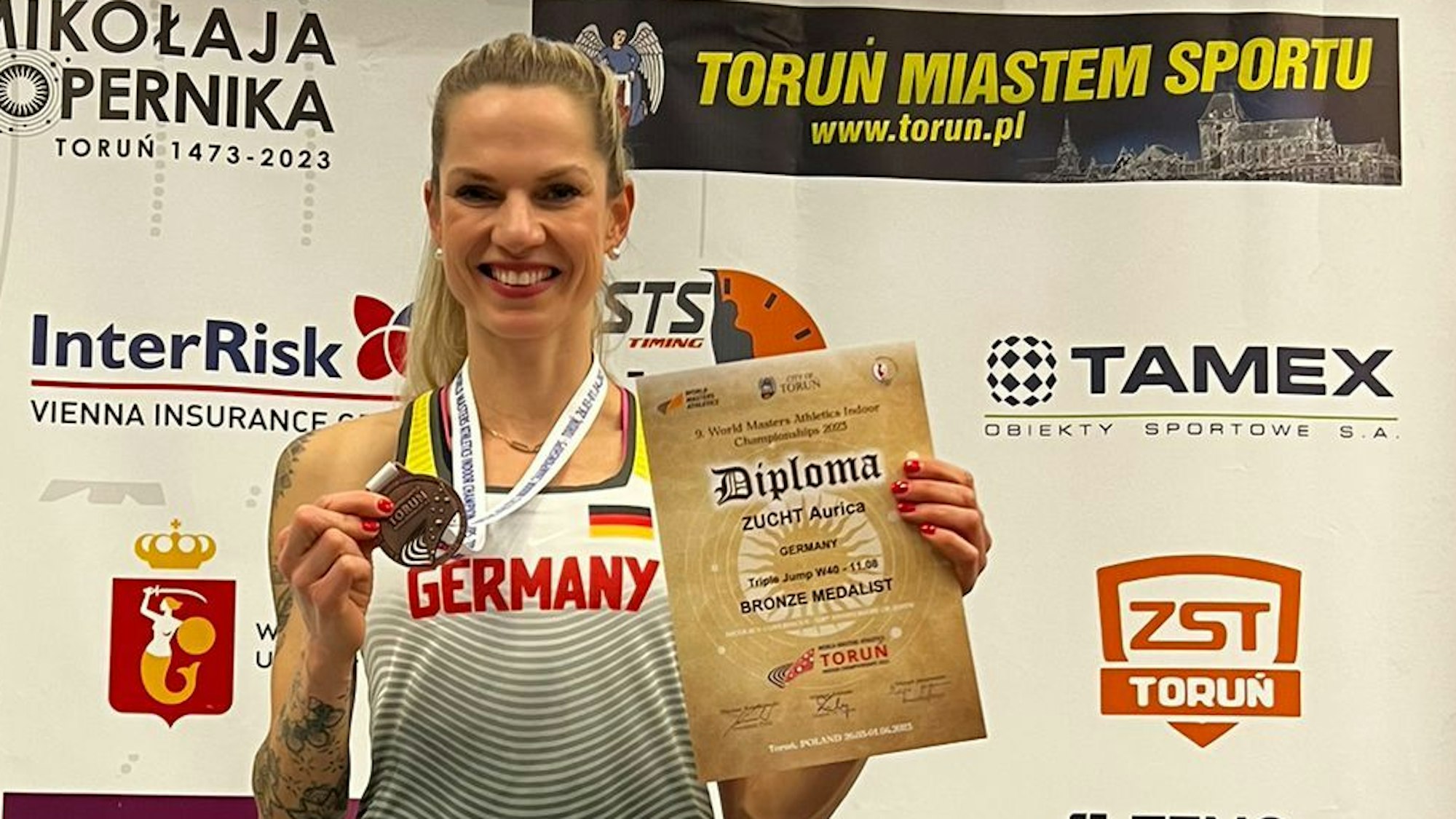 Leichtathletin Aurica Zucht mit Medaille und Urkunde auf dem Siegertreppchen im polnischen Torun.
