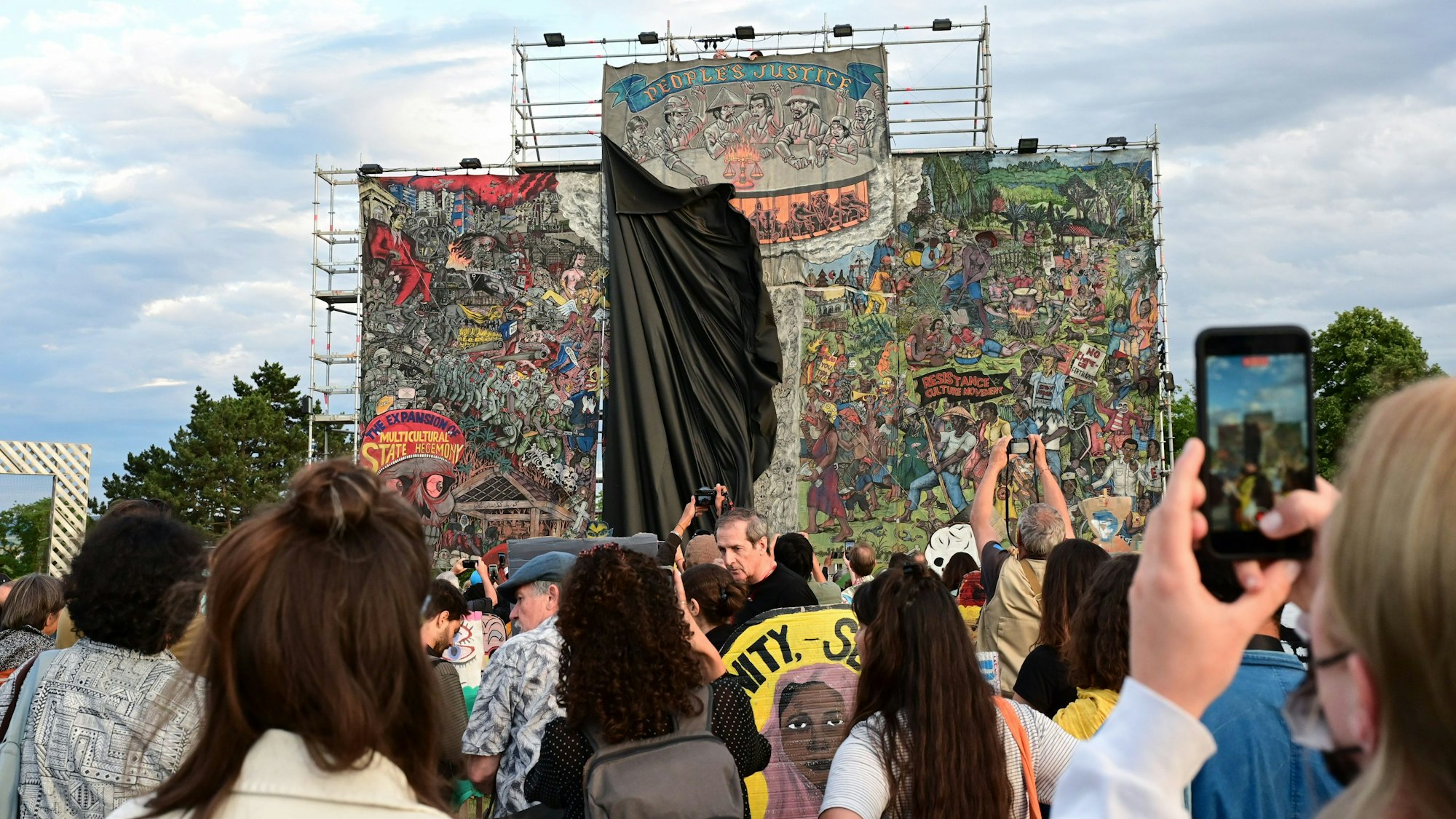 Vor dem Abhängen des umstrittenen Großbanners «People's Justice» des indonesischen Künstlerkollektivs Taring Padi auf dem Friedrichsplatz fällt das am Tag zuvor angebrachte schwarze Tuch.