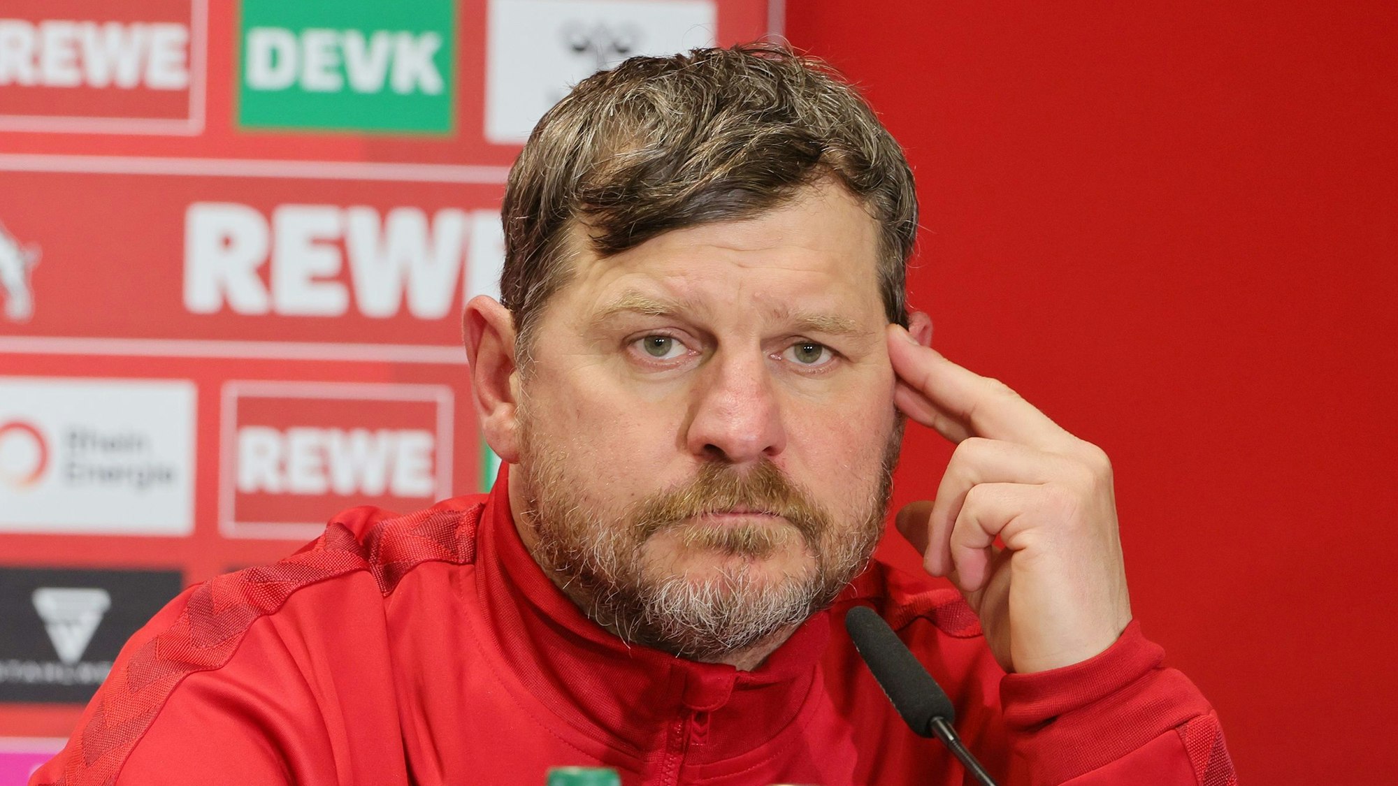 Steffen Baumgart, Trainer des 1. FC Köln, beantwortet auf einer Pressekonferenz Fragen der anwesenden Journalisten. Vor ihm steht ein MIkrofon.