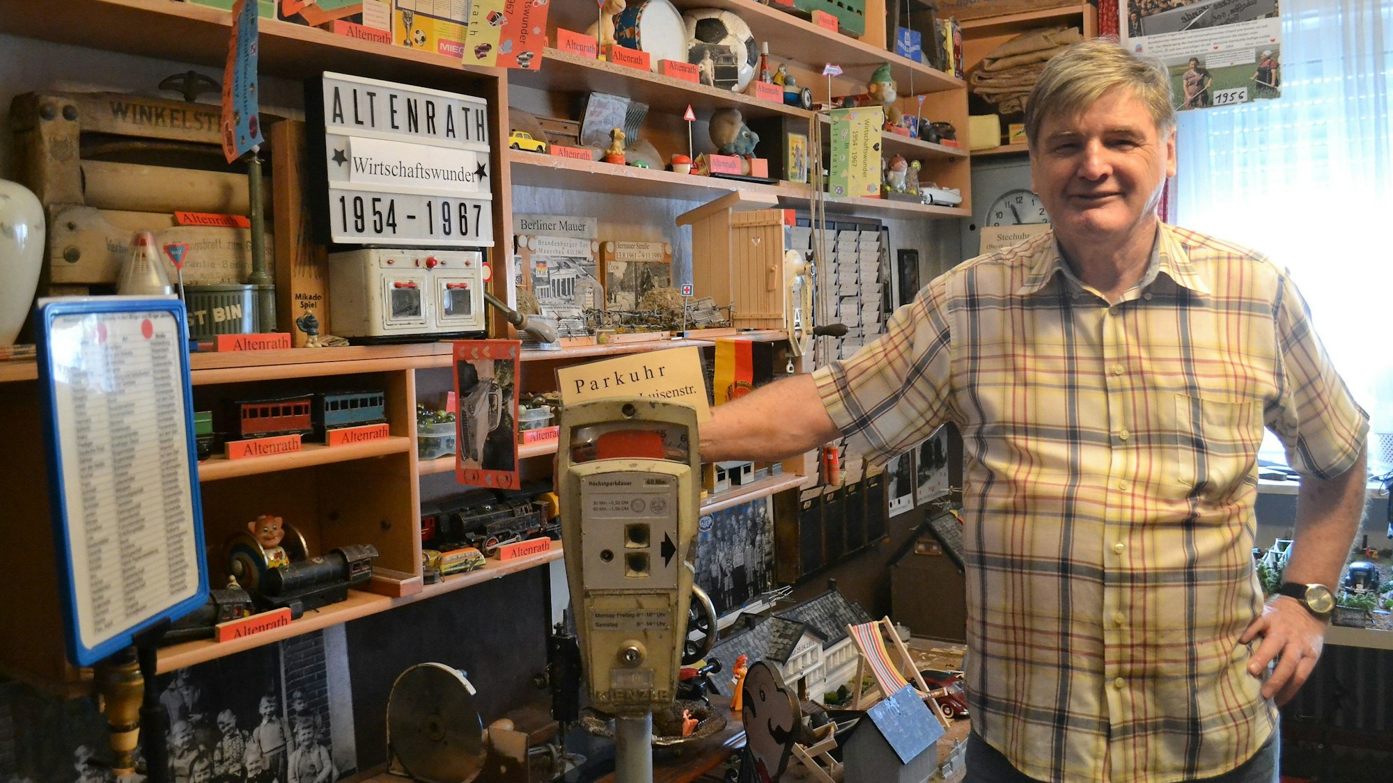 Hans Strobl steht in einem seiner Räume neben einer alten Parkuhr.
