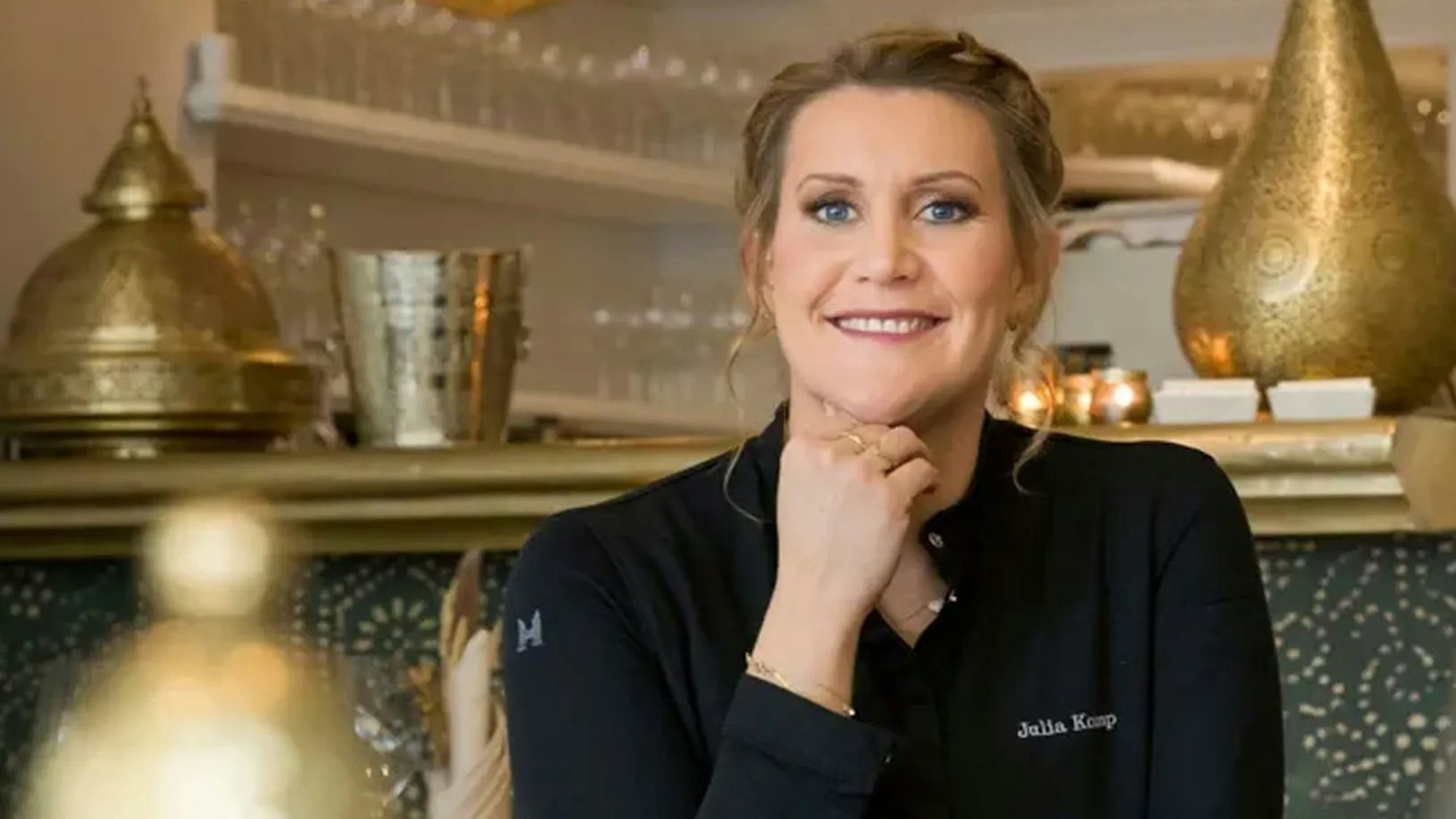 Julia Komp sitzt lächelnd in ihrem Restaurant „Sahila“.