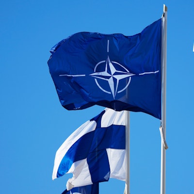 04.04.2023, Finnland, Helsinki: Die Nato-Flagge (M) und die finnische Flagge flattern über dem Gebäude des finnischen Außenministeriums.