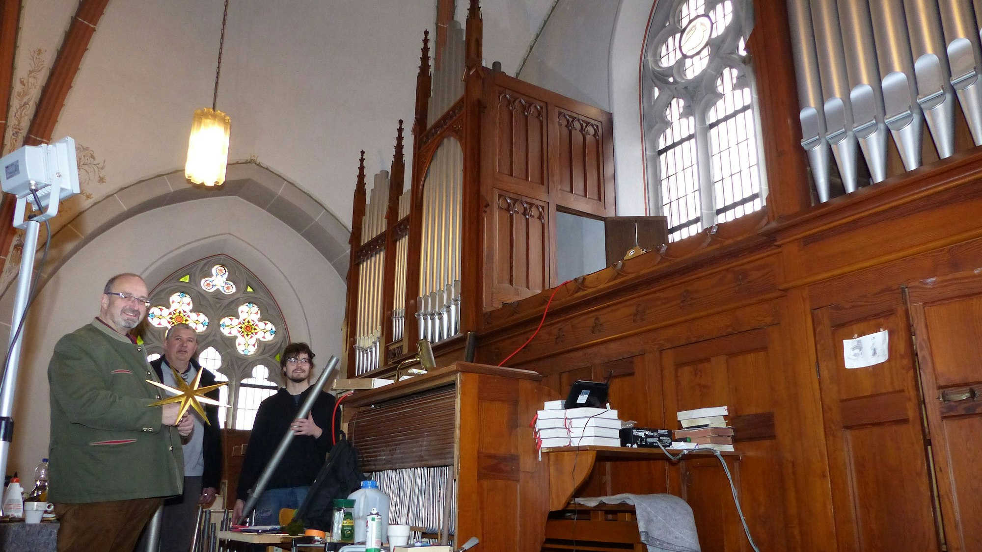 Zu sehen sind drei Männer vor einer Orgel in der Kirche St. Mariä Heimsuchung in Morsbach-Holpe.