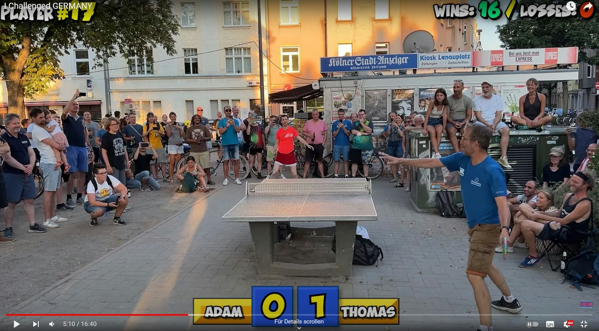 Adam Bobrow, Tischtennis-Youtube-Star (im Hintergrund im roten T-Shirt), spielt an einer Tischtennisplatte am Kölner Lenauplatz gegen Thomas Roßkopf.