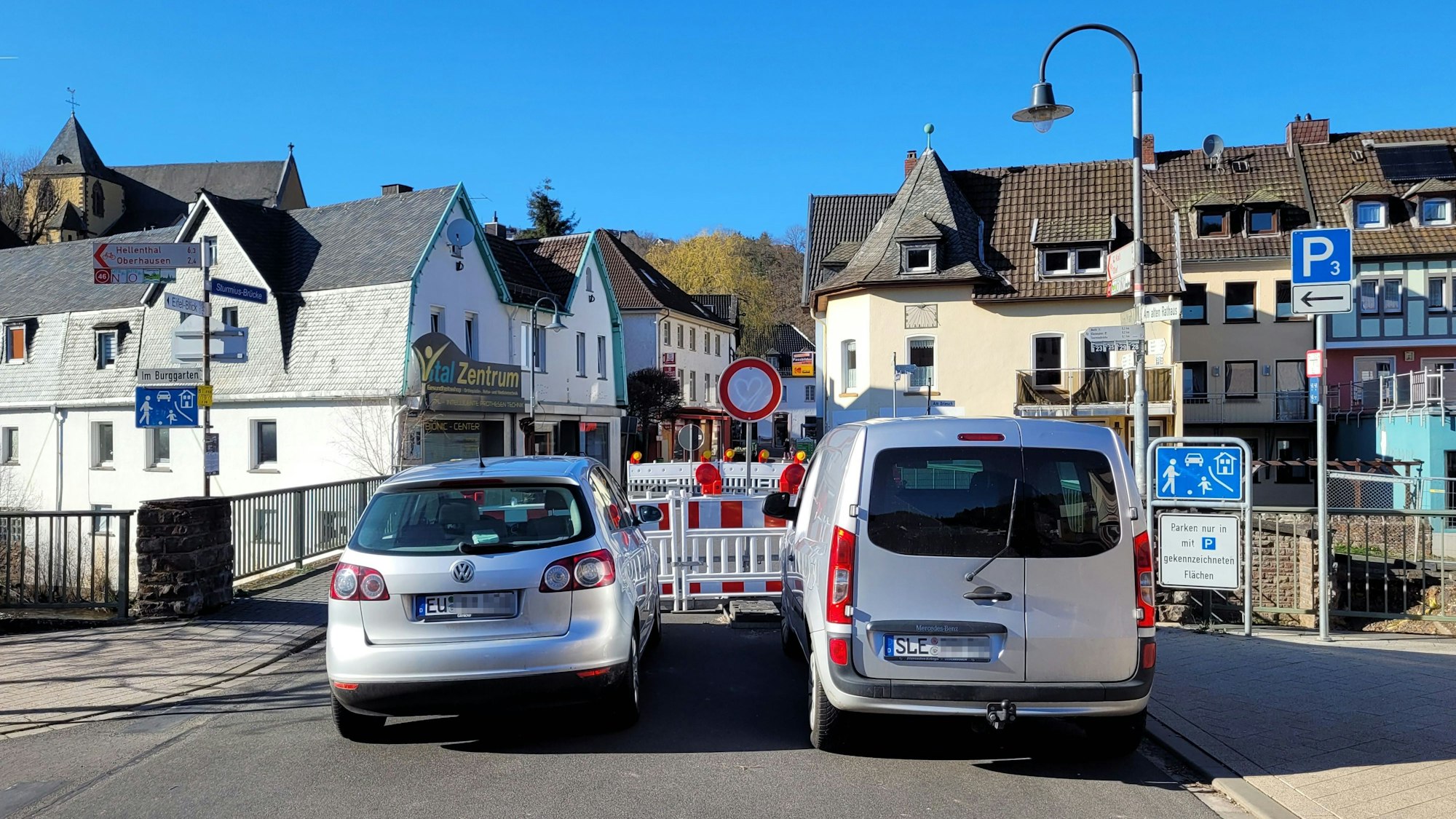 Zwei Autos halten vor Warnschildern, welche die Sperrung einer Brücke anzeigen.