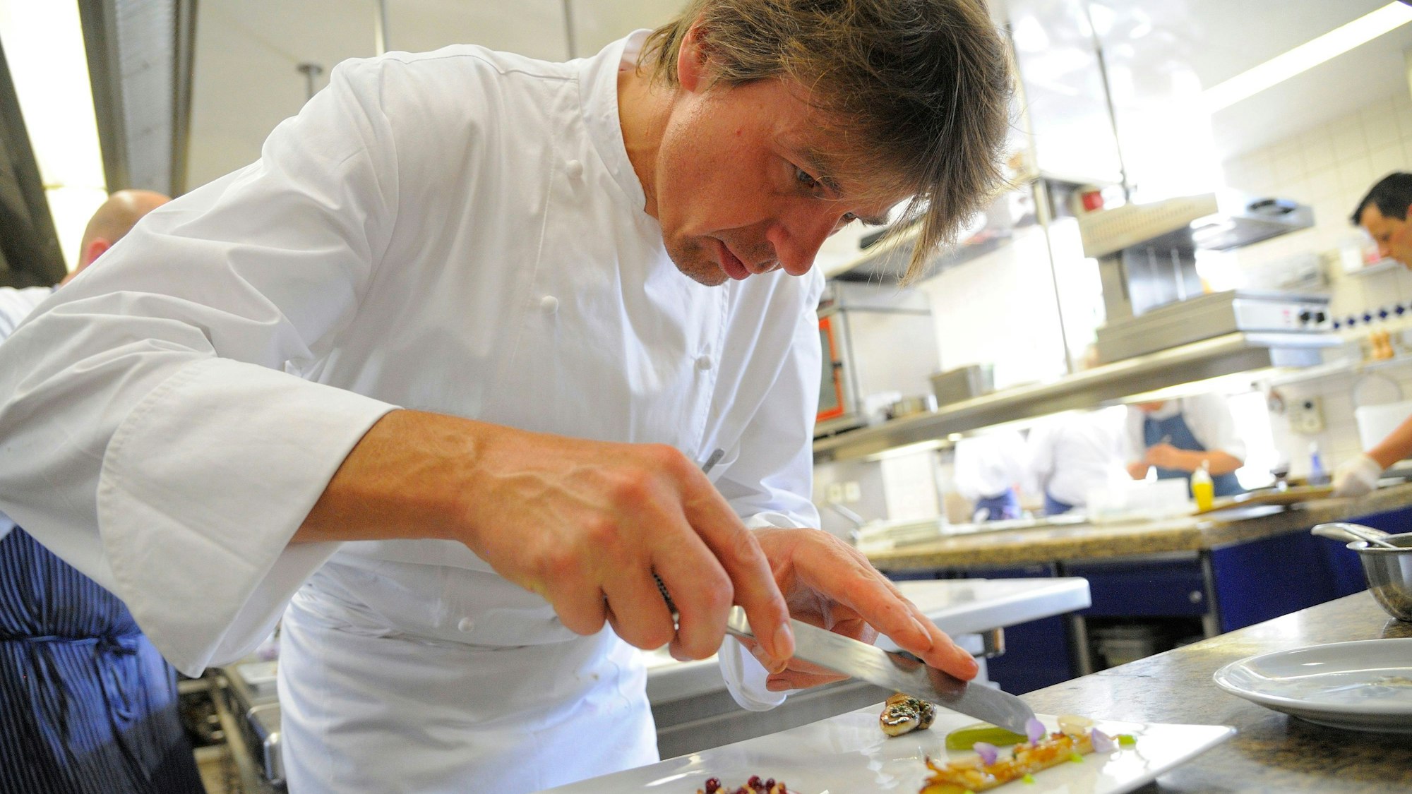 Joachim Wissler ist Koch der Zwei-Sterne-Küche im Restaurant Vendome im Grandhotel Schloss Bensberg. Hier ist er konzentriert bei der Arbeit in der Küche zu sehen.