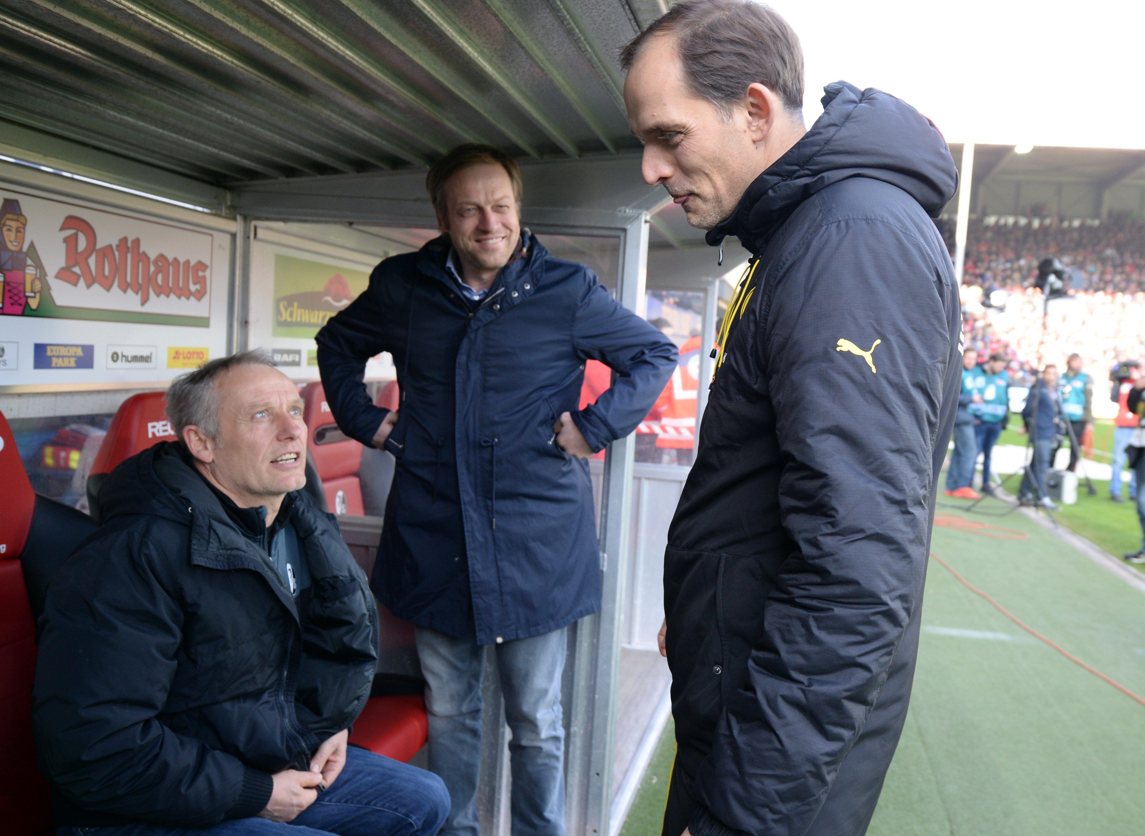 Trainer Christian Streich und Sportdirektor Klemens Hartenbach von Freiburh sprechen vor dem Spiel mit Trainer Thomas Tuchel von Dortmund (l-r). Streich und Tuchel treffen nun im Pokal aufeinander.