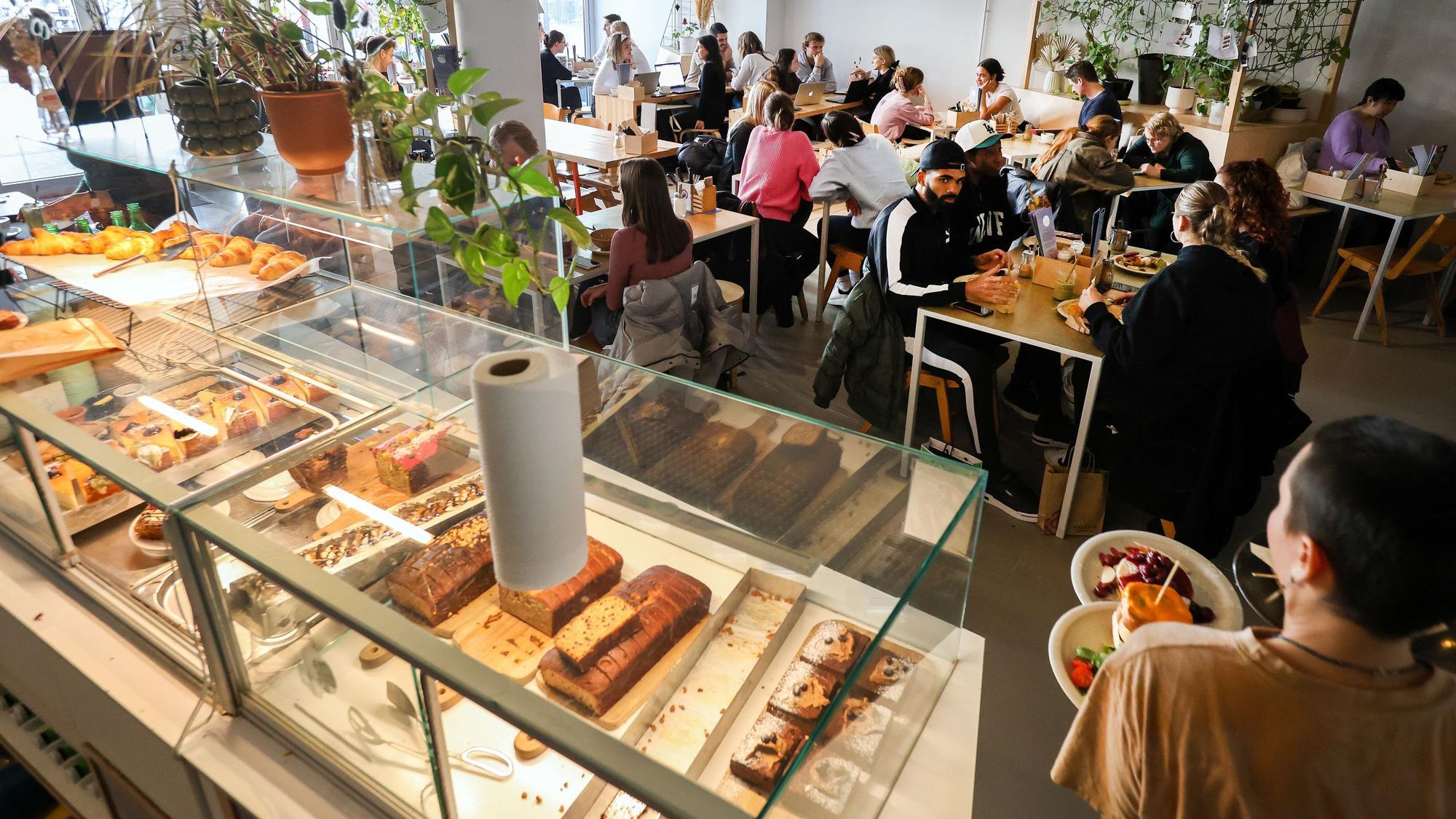 Innenansichten des Kaffeesaurus mit der großen Kuchentheke und Gästen