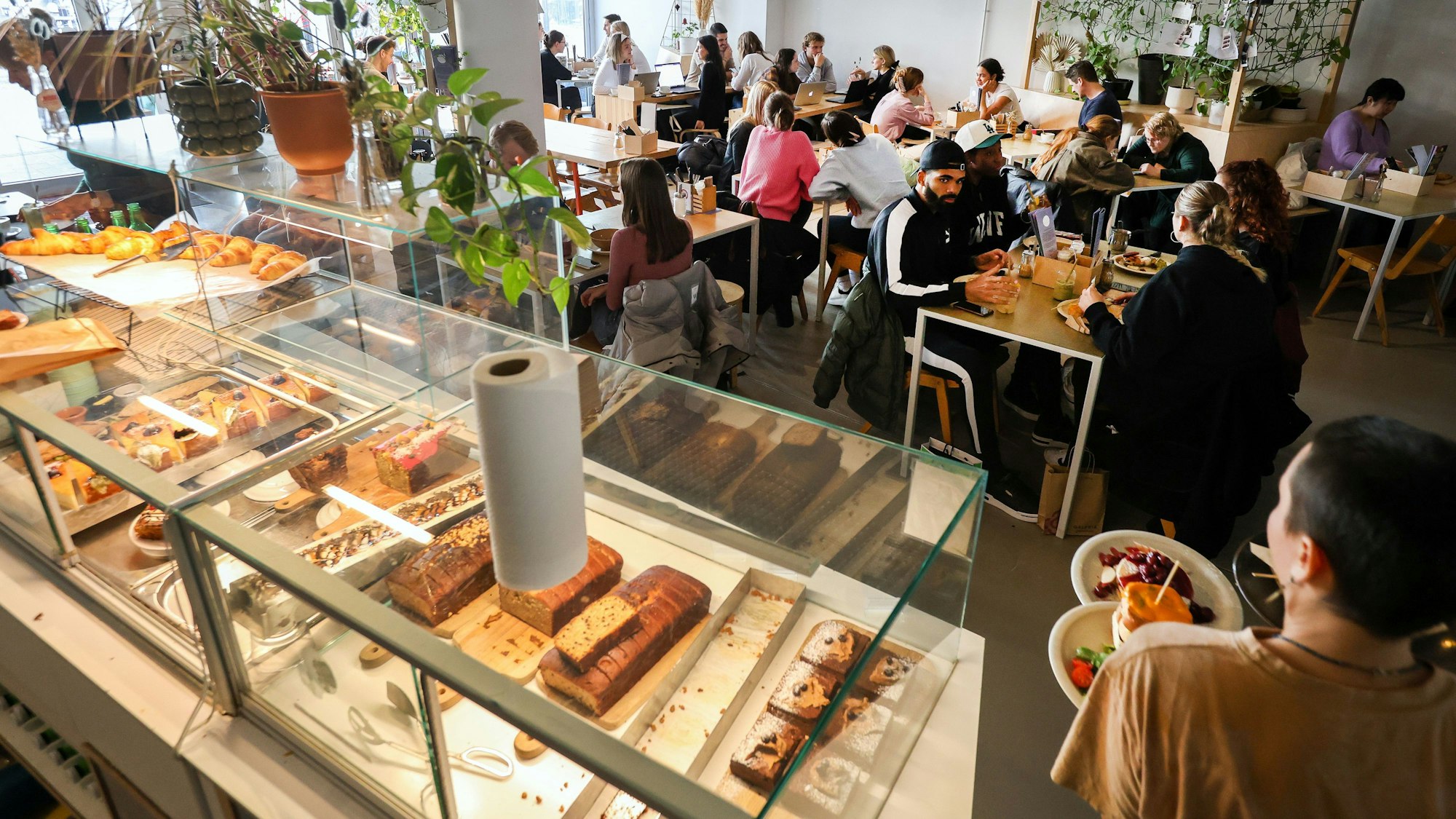 Innenansichten des Kaffeesaurus mit der großen Kuchentheke und Gästen