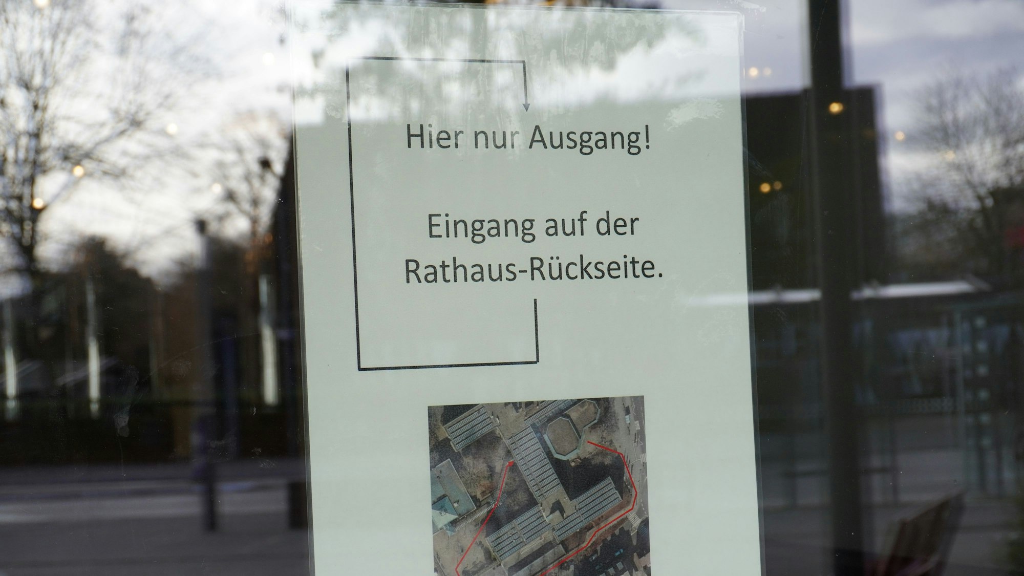 Aushang hinter lichtreflektierender Tür weist darauf hin, dass es sich bei dem Durchgang nur um einen Ausgang handelt. Der Eingang finde sich laut Aushang auf der Rathaus-Rückseite.