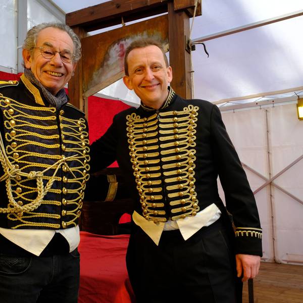 Dr. Michael Faber (l.) übergibt das Fallbeil beim "Jahrmarkt anno dazumal" im Freilichtmuseum Kommern an den Variete-Künstler Jeton.