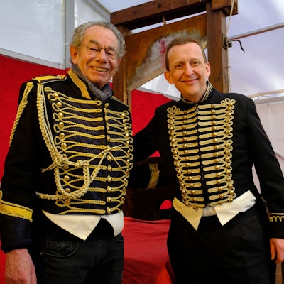Dr. Michael Faber (l.) übergibt das Fallbeil beim "Jahrmarkt anno dazumal" im Freilichtmuseum Kommern an den Variete-Künstler Jeton.