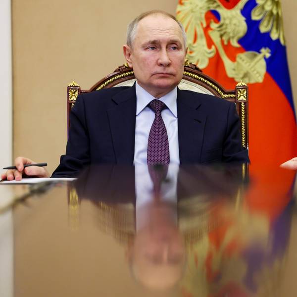 Der russische Präsident Wladimir Putin sitzt an einem Tisch im Kreml. Im Hintergrund ist die russische Flagge zu sehen.