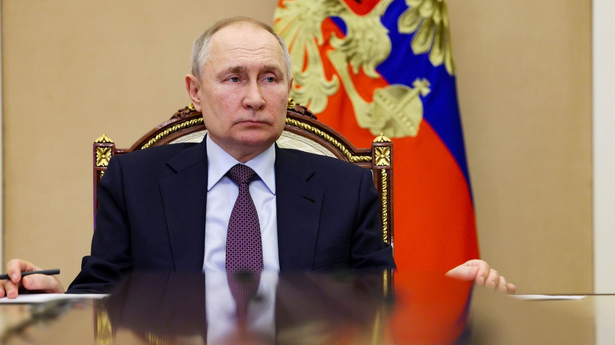 Der russische Präsident Wladimir Putin sitzt an einem Tisch im Kreml. Im Hintergrund ist die russische Flagge zu sehen.