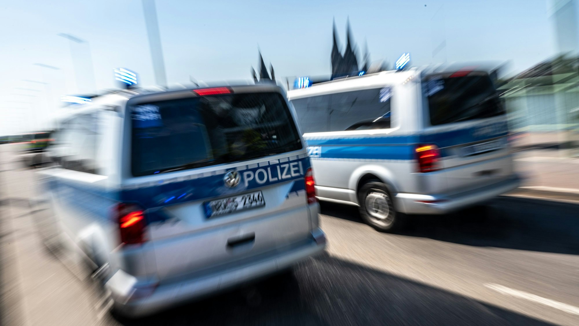 Polizeifahrzeuge sind mit Blaulicht auf der Deutzer Brücke im Einsatz.