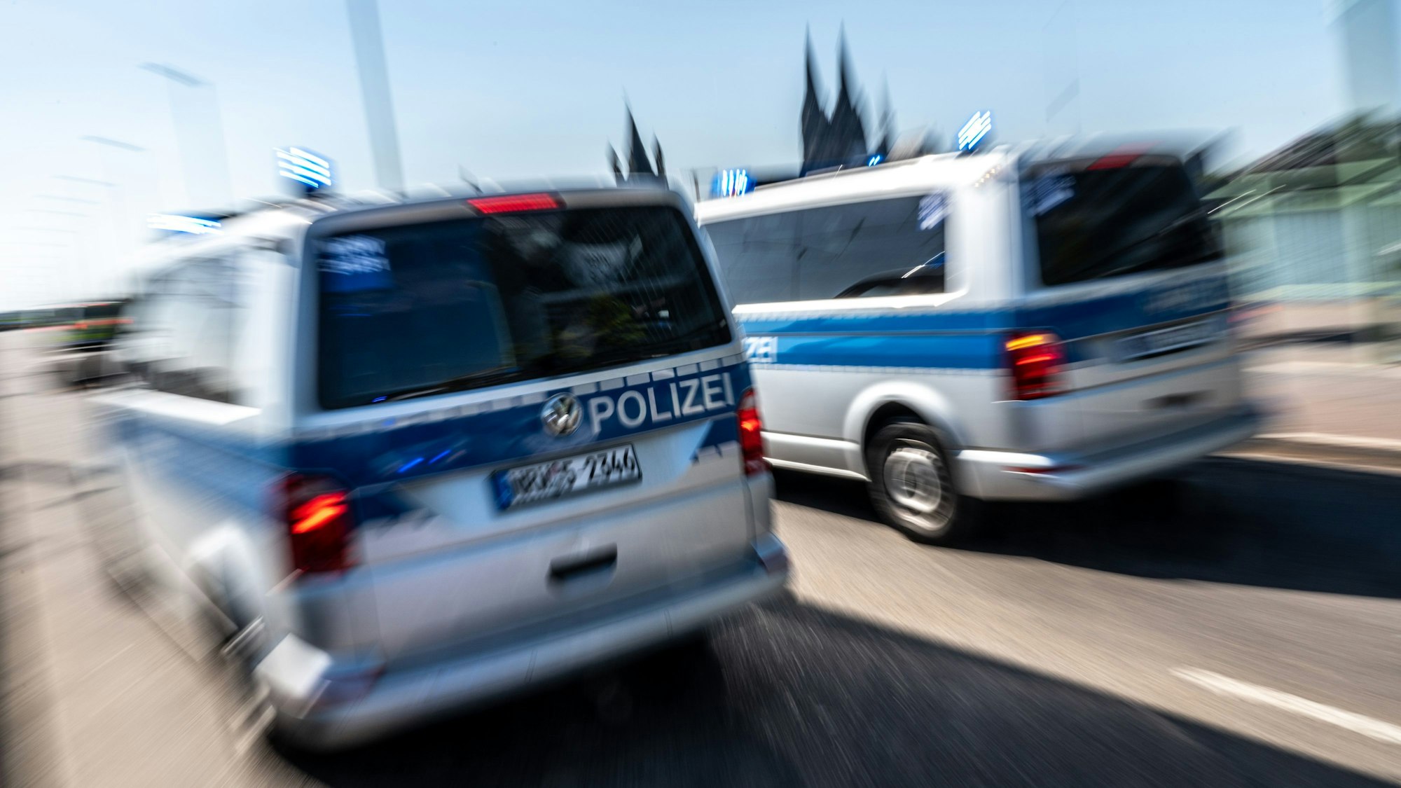 Polizeifahrzeuge sind mit Blaulicht auf der Deutzer Brücke im Einsatz. (Symbolbild)