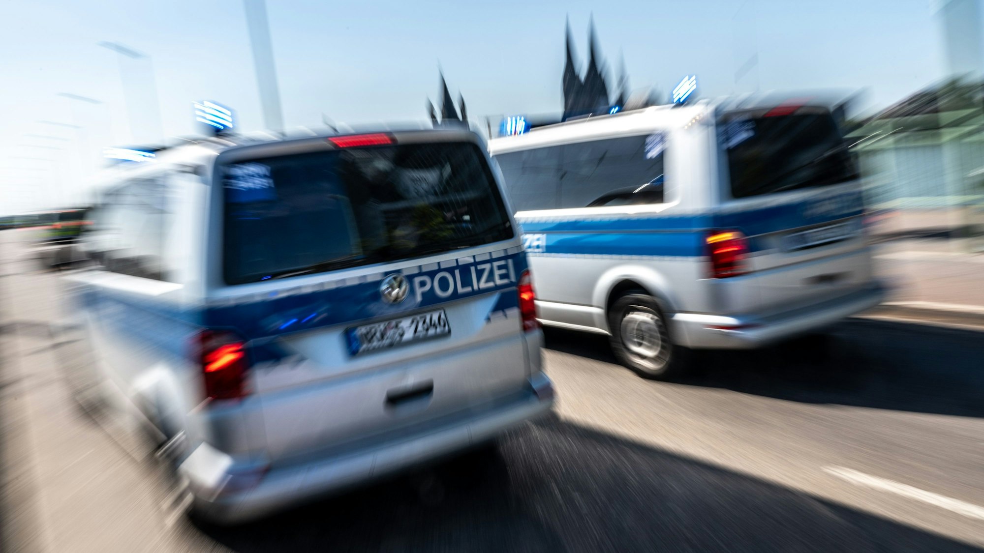 Polizeifahrzeuge sind mit Blaulicht auf der Deutzer Brücke im Einsatz. (Symbolbild)