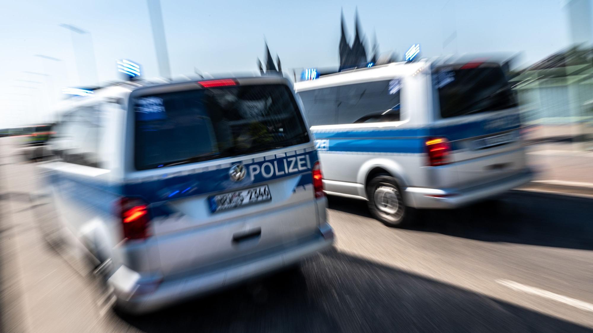 Zwei Polizeifahrzeuge auf der Deutzer Brücke mit dem Dom im Hintergrund