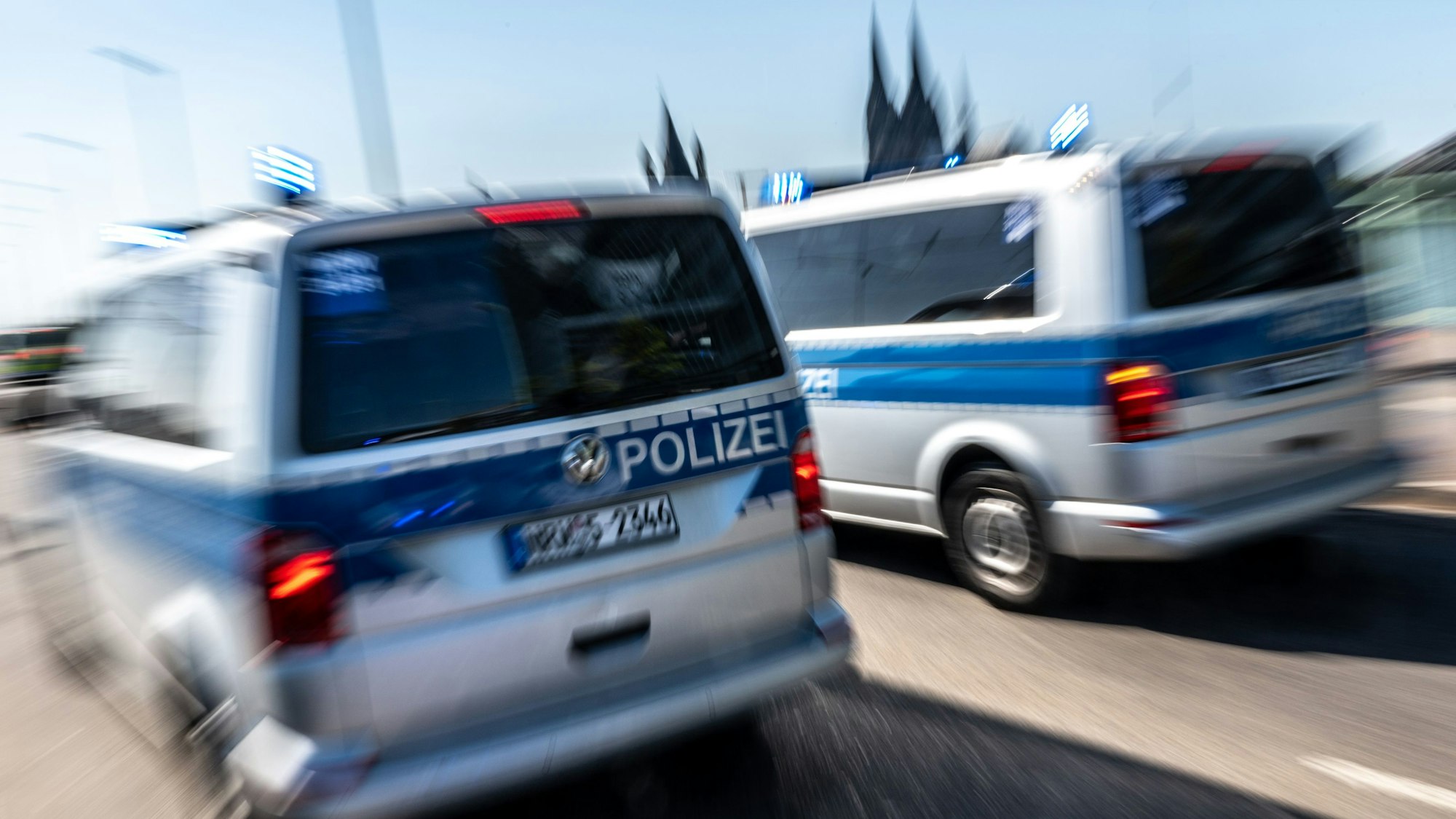 Polizeifahrzeuge sind mit Blaulicht auf der Deutzer Brücke in Köln im Einsatz.