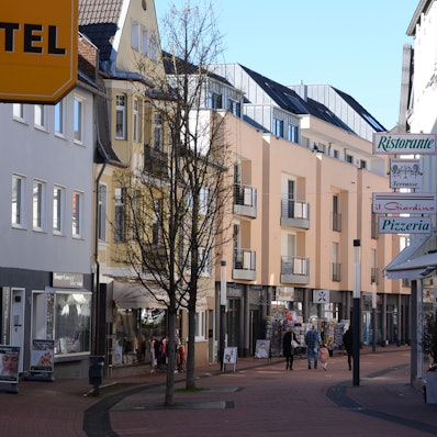 Menschen laufen durch eine Fußgängerzone.